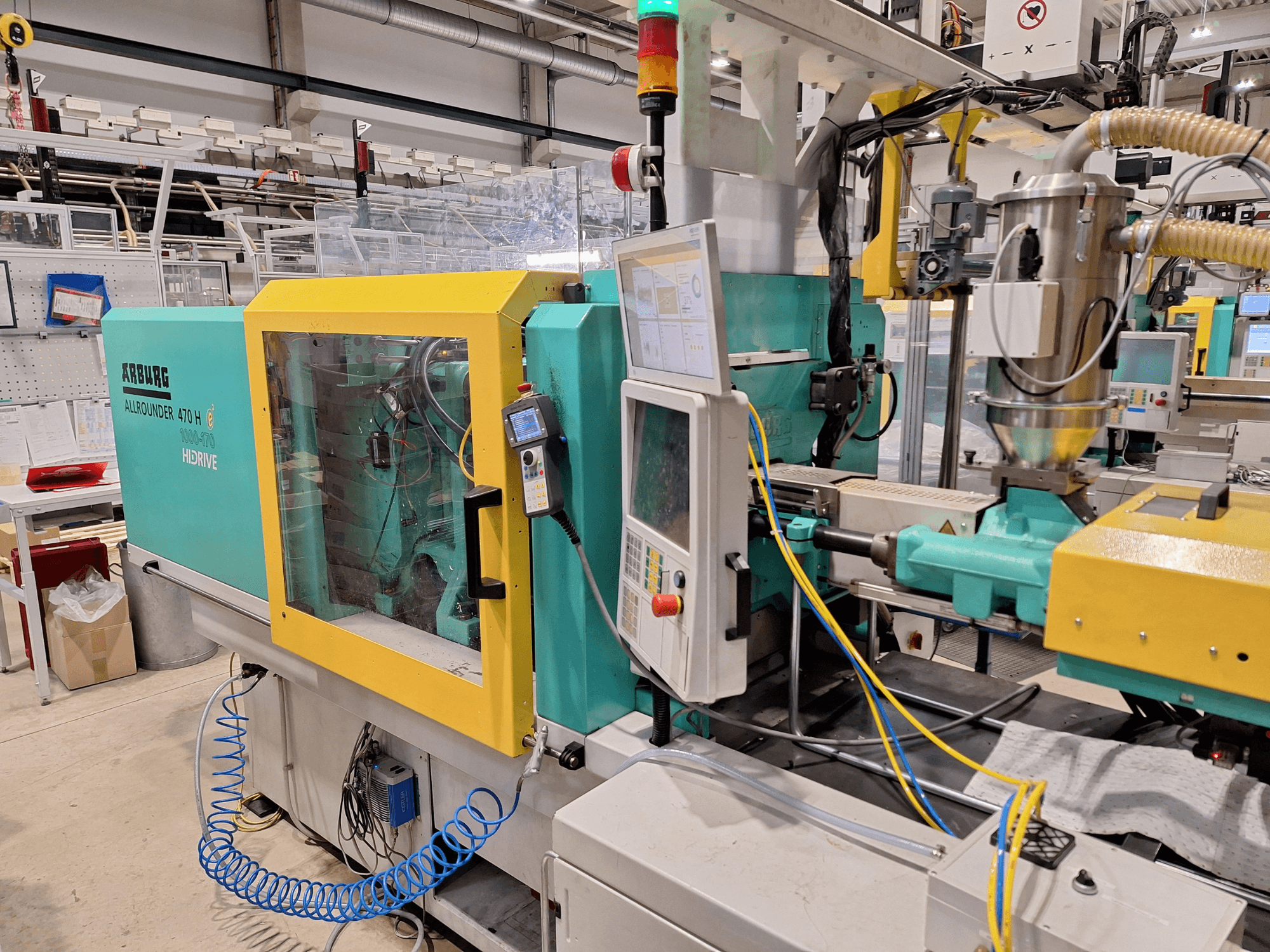 Arburg 470 H 1000-170 hidraulični stroj za brizganje plastike, bočni pogled s upravljačkom pločom i sustavom za dovod.