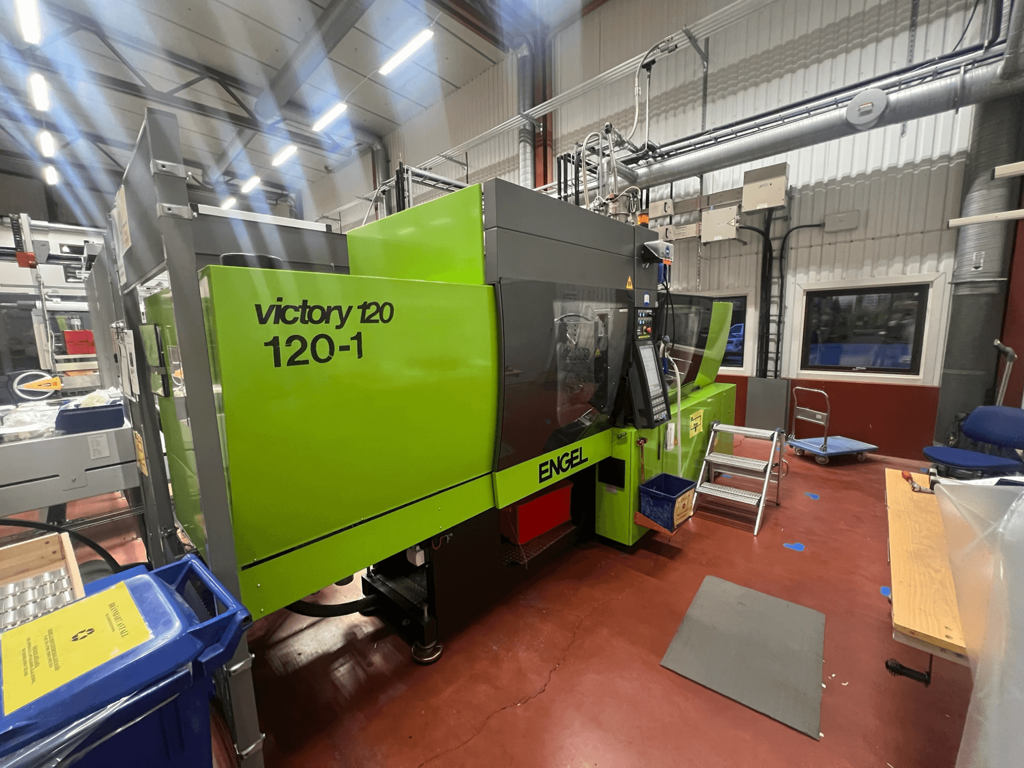 Zeleni stroj za brizganje plastike ENGEL Victory 120-1, prednji pogled, s upravljačkom pločom i stepenicama, u industrijskom okruženju.