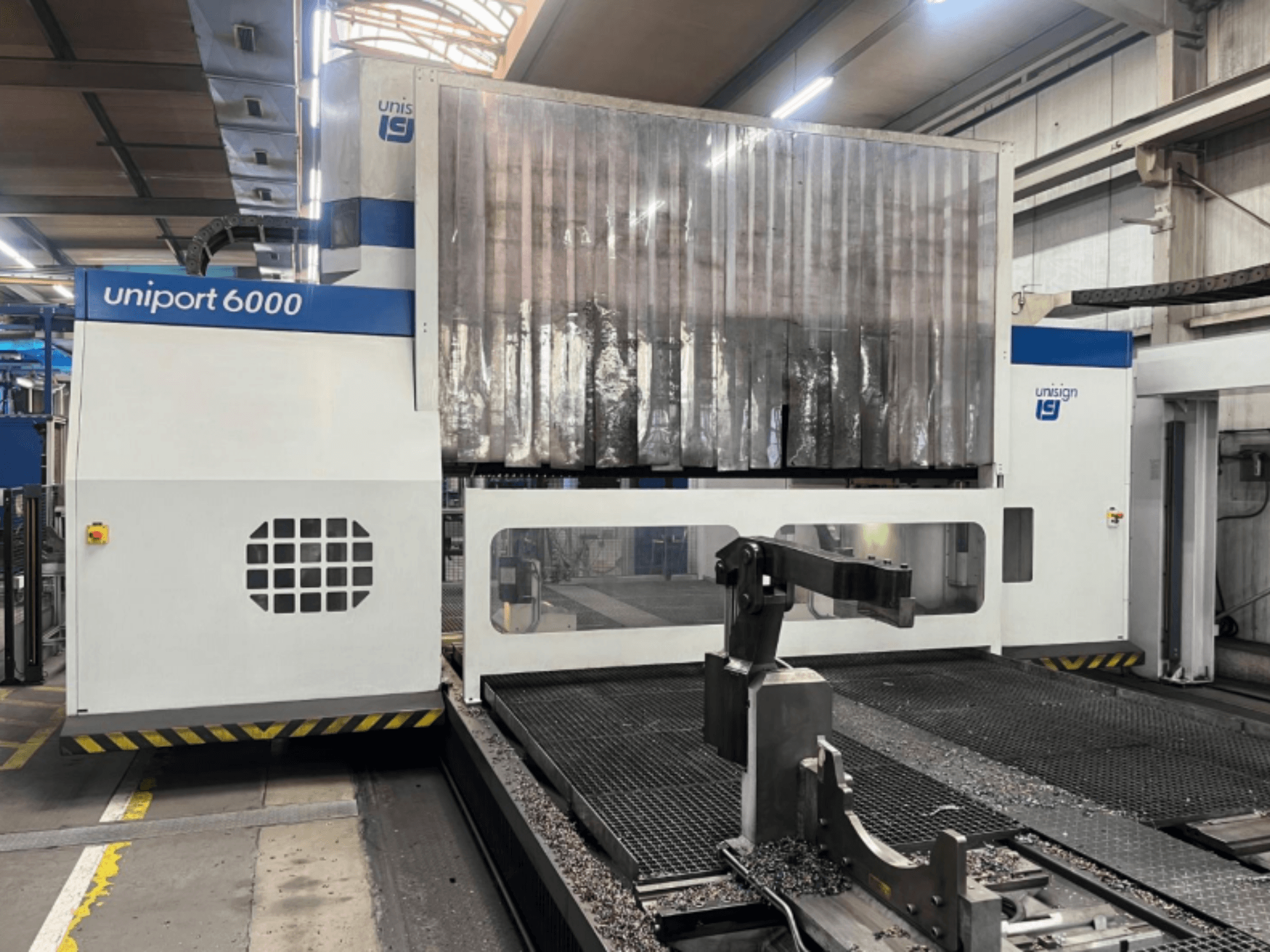 Portalna glodalica Unisign uniport 6000, prednji pogled, prikazuje strukturu stroja i područje rezanja metalnim strugotinama.