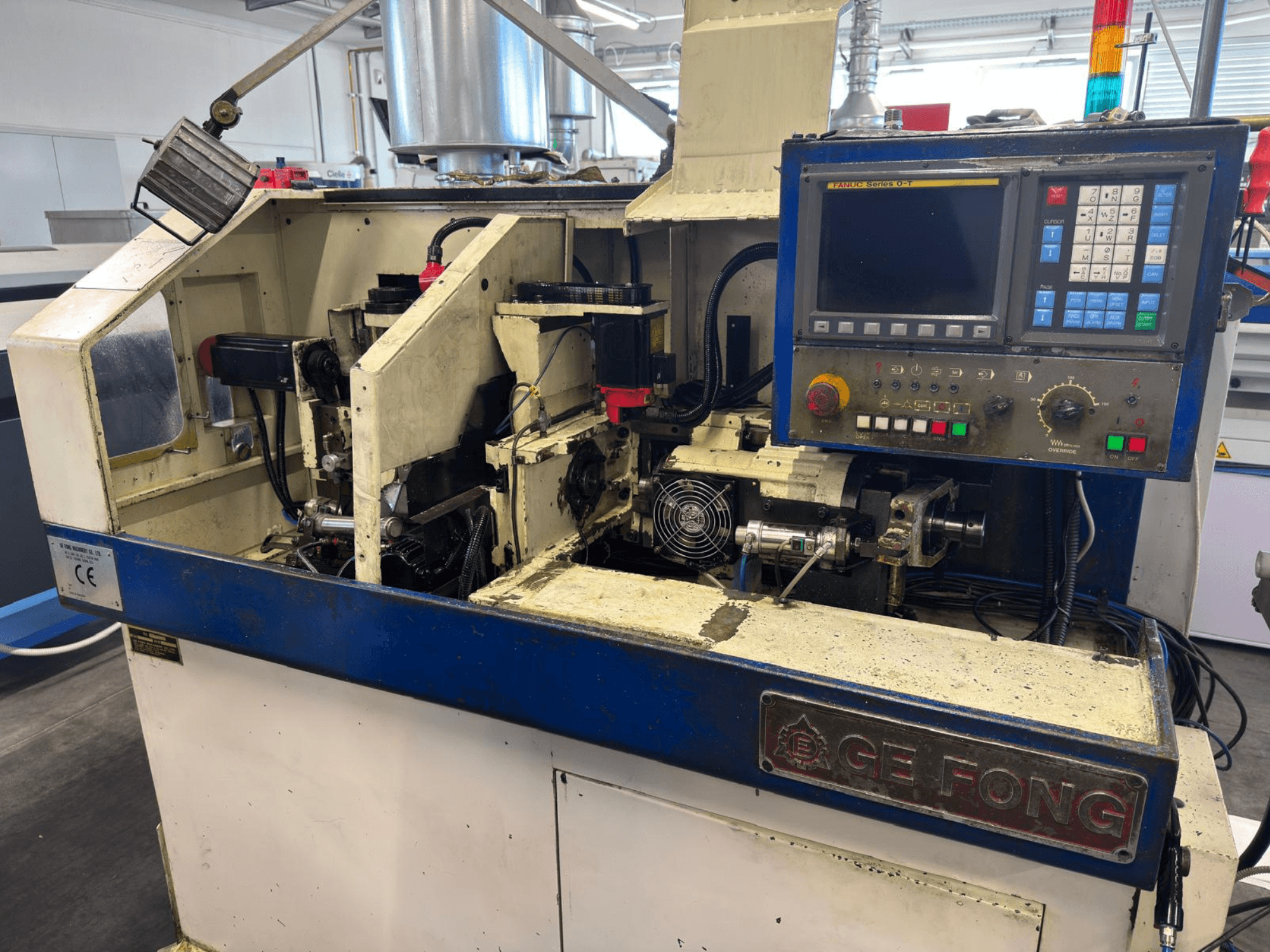 Industrijski stroj GE FONG u prednjem pogledu, s prikazom unutarnjih komponenti, upravljačke ploče i operativnih dijelova.