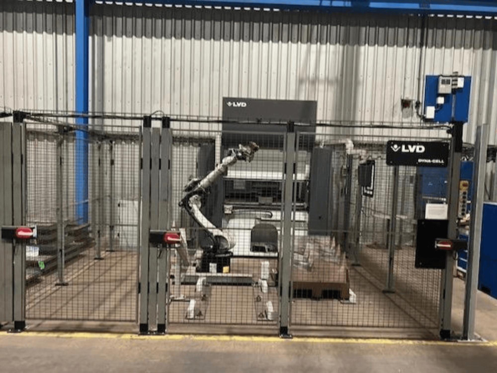 LVD Dyna-Cell robotska radna stanica u ograđenom prostoru, prednji pogled, s robotskom rukom i upravljačkom pločom.