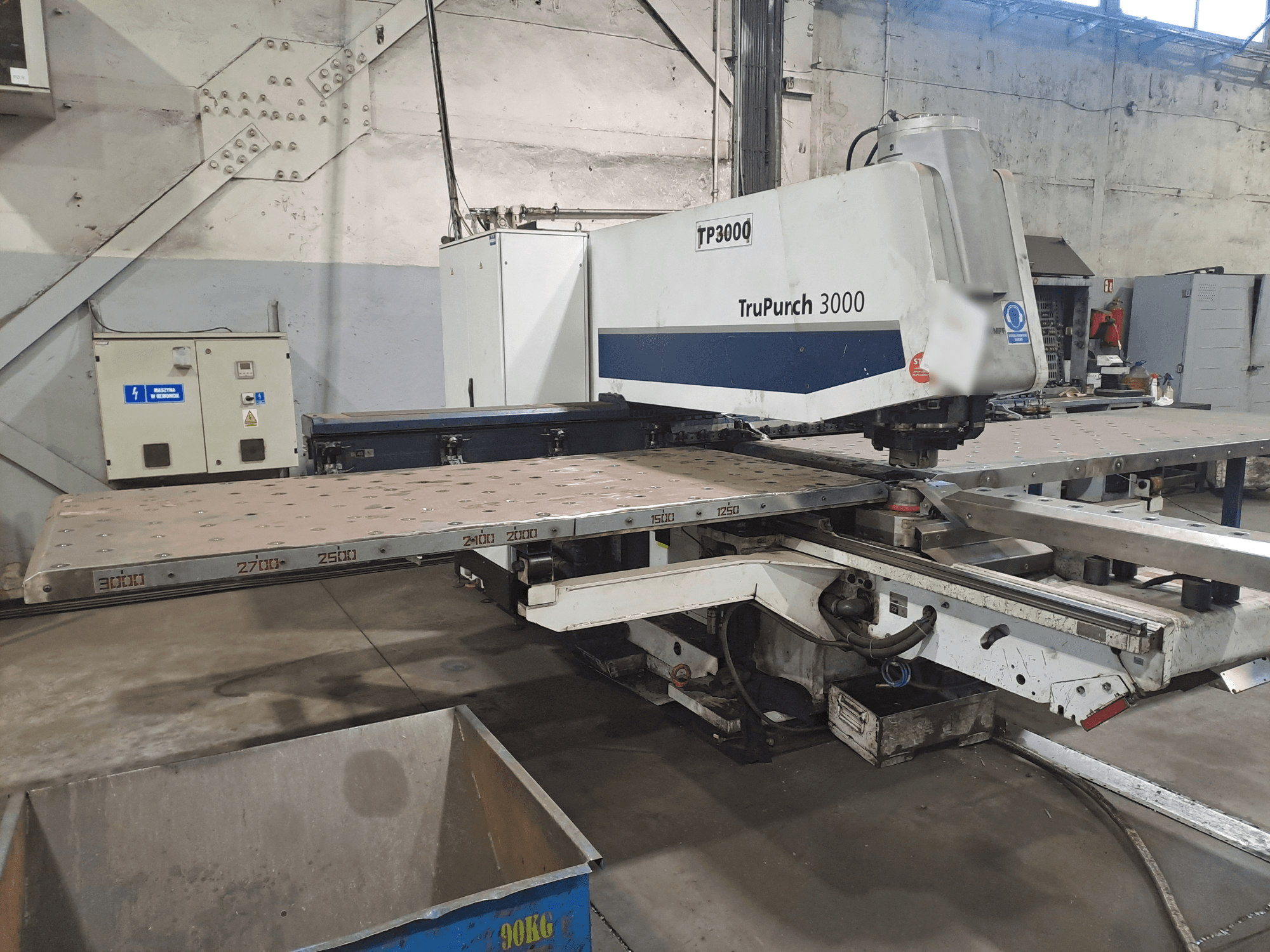 CNC stroj TruPunch 3000 prikazan s prednje strane, s velikom metalnom pločom i oznakama za mjerenje, u industrijskom okruženju.