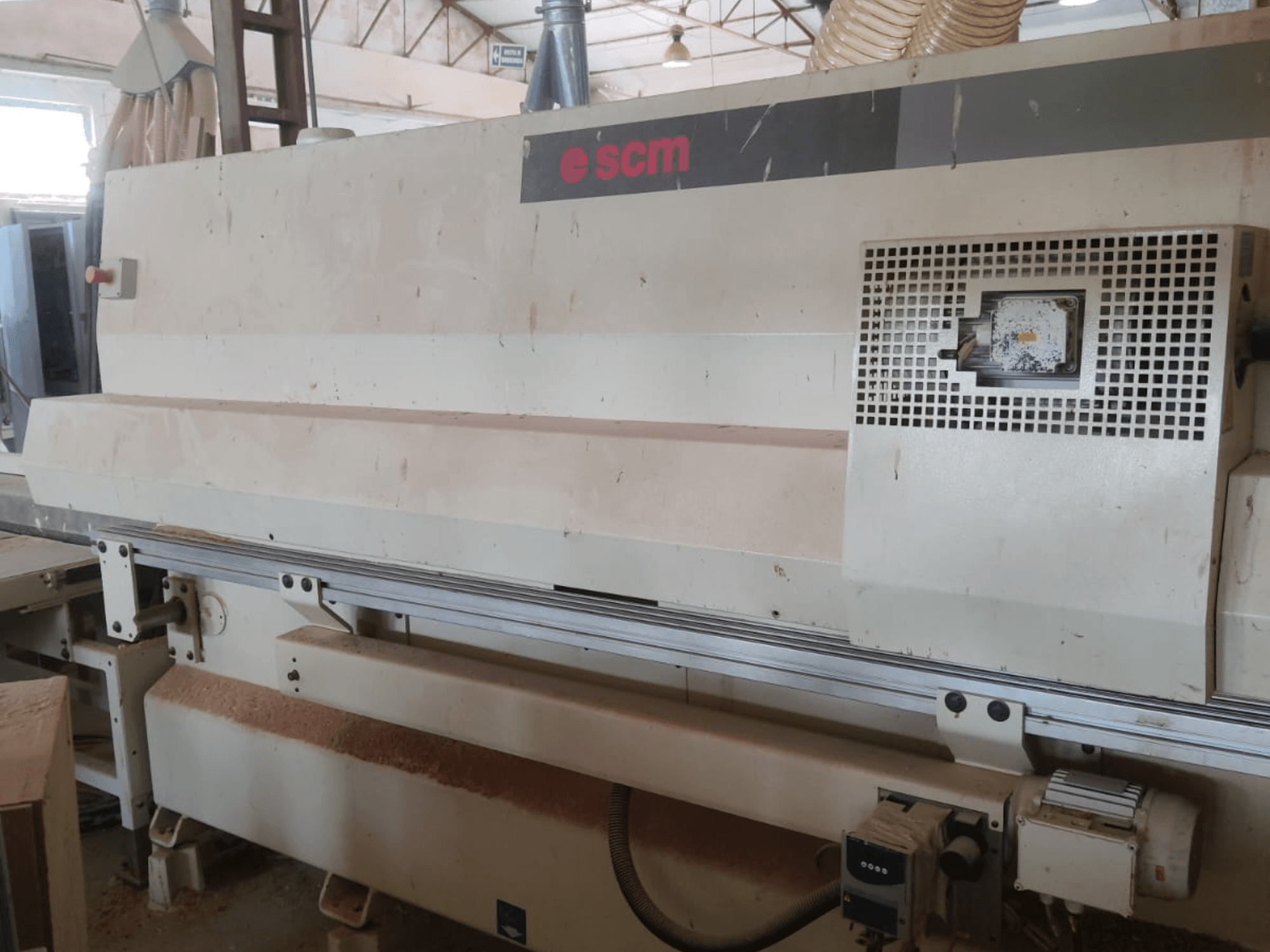 CNC centar za obradu drva SCM Windor60, prednji pogled. Prikazuje upravljačke elemente stroja i sustav za sakupljanje prašine, s drvenim strugotinama ispod.