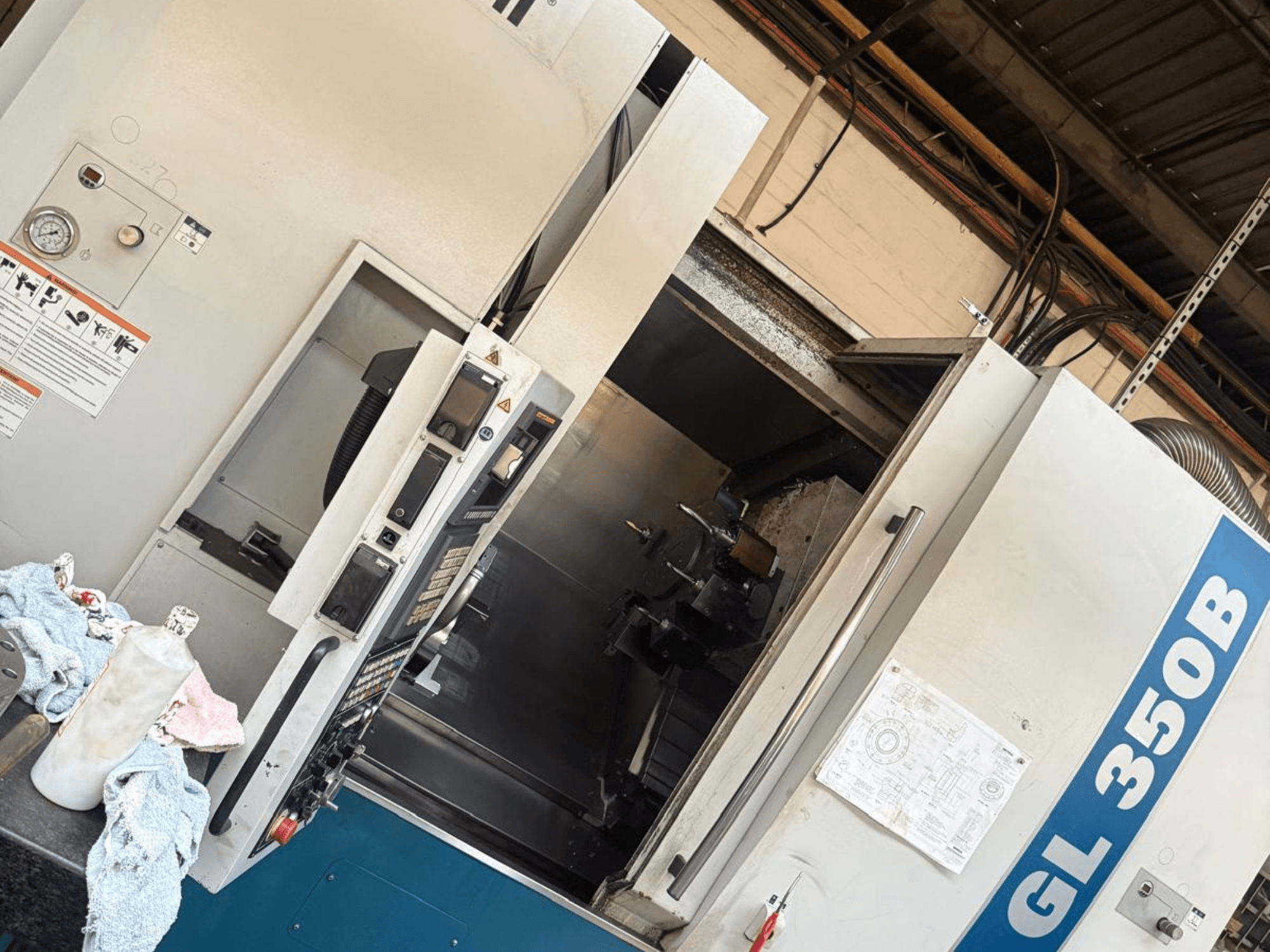 Horizontalni tokarski stroj Romi GL 350B, prednji pogled, s upravljačkom pločom i otvorenim vratima koja otkrivaju unutrašnjost.