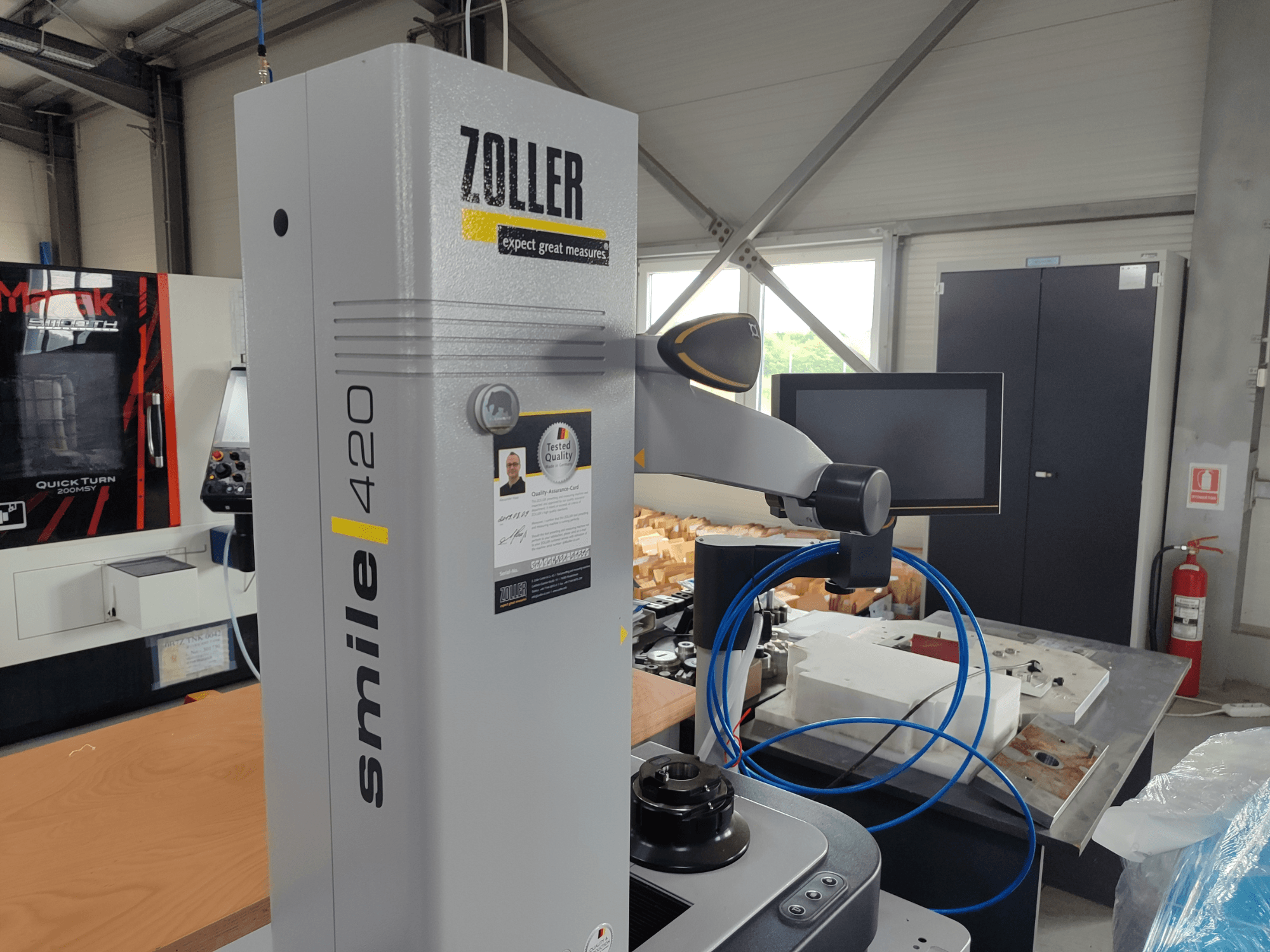 ZOLLER smile 420 mjerni uređaj s monitorom, bočni pogled u radionici, s plavim crijevima i strojevima u pozadini.