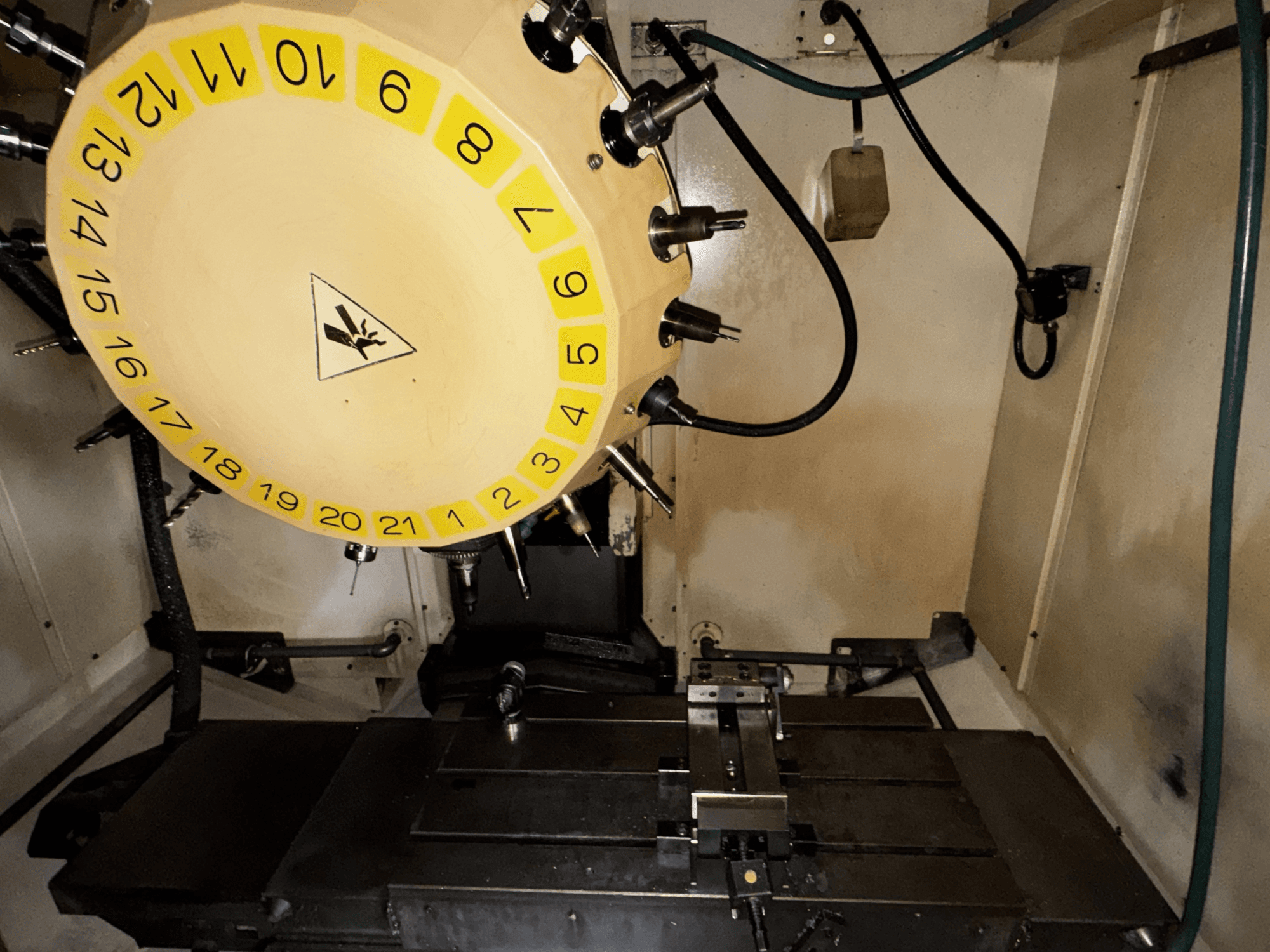 Unutrašnjost vertikalnog obradnog centra FANUC Robodrill alpha-T21iFL s vidljivim alatnim karuselom i obradnim stolom.