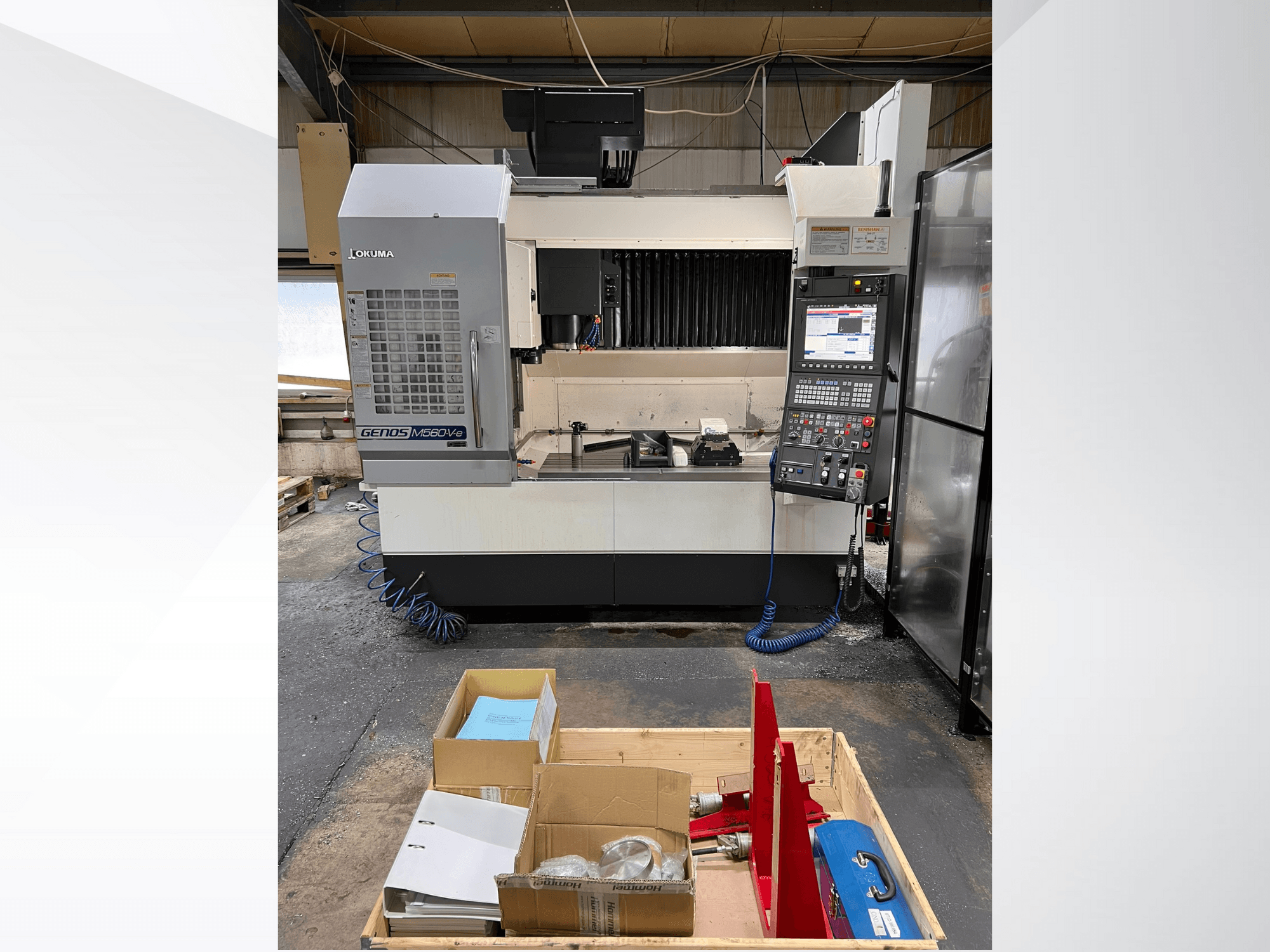 Vertikalni obradni centar Okuma GENOS M460V-5, prednji pogled, s vidljivom upravljačkom pločom i alatima na radnom stolu.