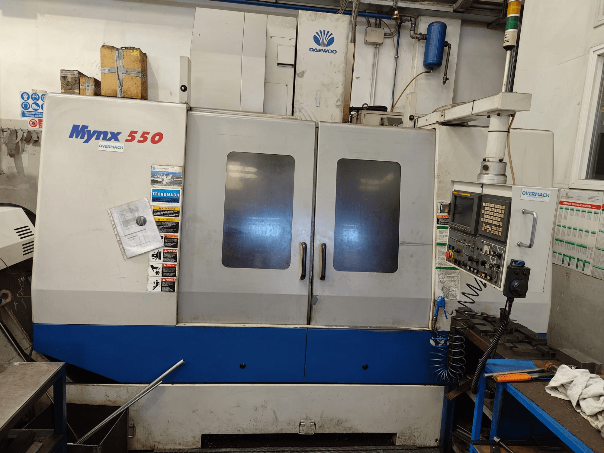 Vertikalni obradni centar DAEWOO MYNX 550, prednji pogled, s upravljačkom pločom, dvoja velika vrata i sigurnosnim naljepnicama.