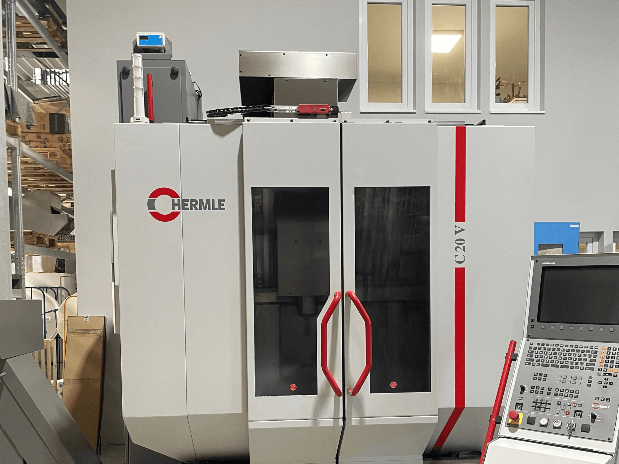 Chermle C20 V CNC stroj, prednji pogled, s upravljačkom pločom i crvenim ručkama; industrijski dizajn s velikim staklenim vratima.