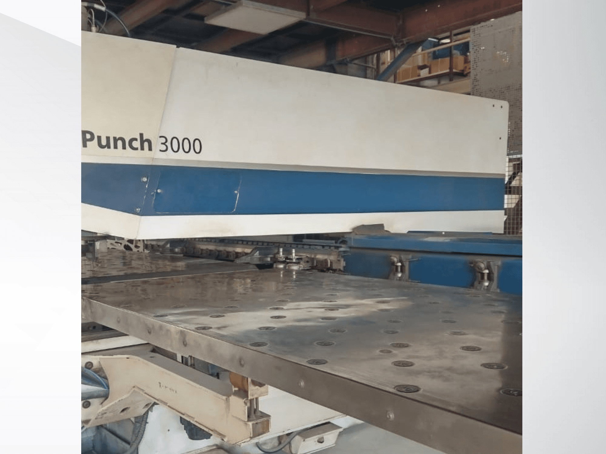 Stroj Punch 3000 u radionici, prednji pogled, prikazuje veliku, ravnu metalnu površinu s više rupa za bušenje.