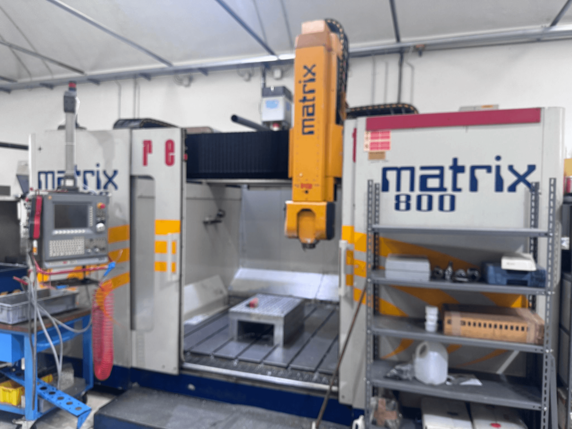 CNC stroj Matrix 800 u prikazu radionice, s upravljačkom pločom, alatima i radnim stolom s raznim predmetima.