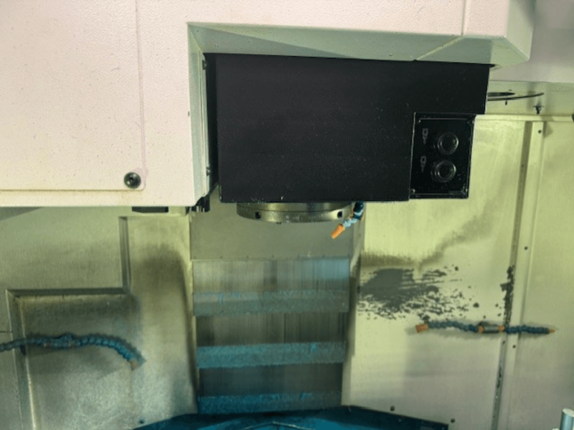 Krupni plan upravljačke ploče i držača alata CNC glodalice, s prikazom detalja marke, gumba i radne površine.