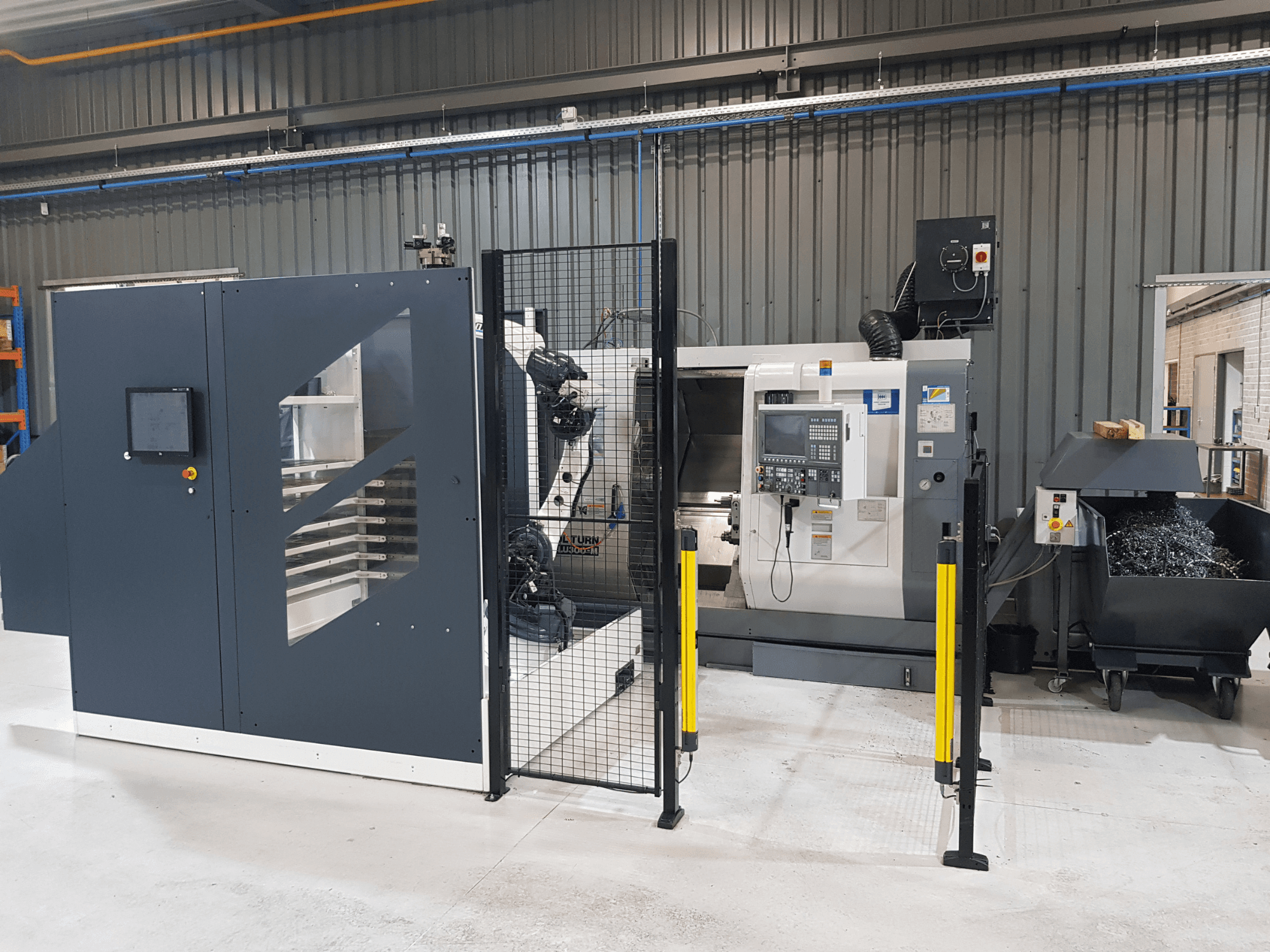 ALTURN automatizirani tokarski stroj i CNC stroj prikazani u tvorničkom okruženju; prednji pogled s vidljivom upravljačkom pločom i sigurnosnom ogradom.