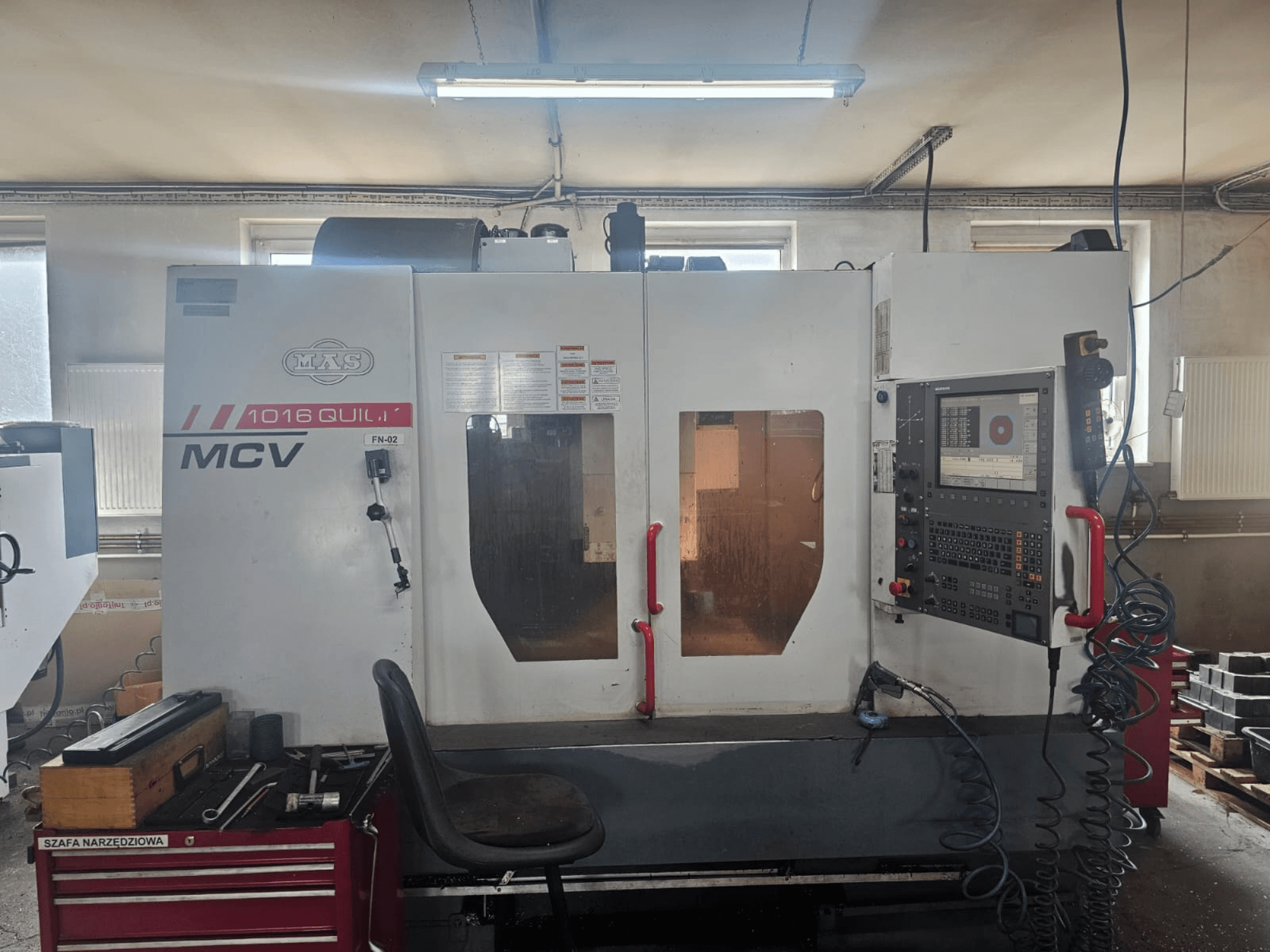 MVS MCV 1016 QUILL CNC stroj, prednji pogled, s upravljačkom pločom, ladicom za alate i radnim prostorom s alatima.