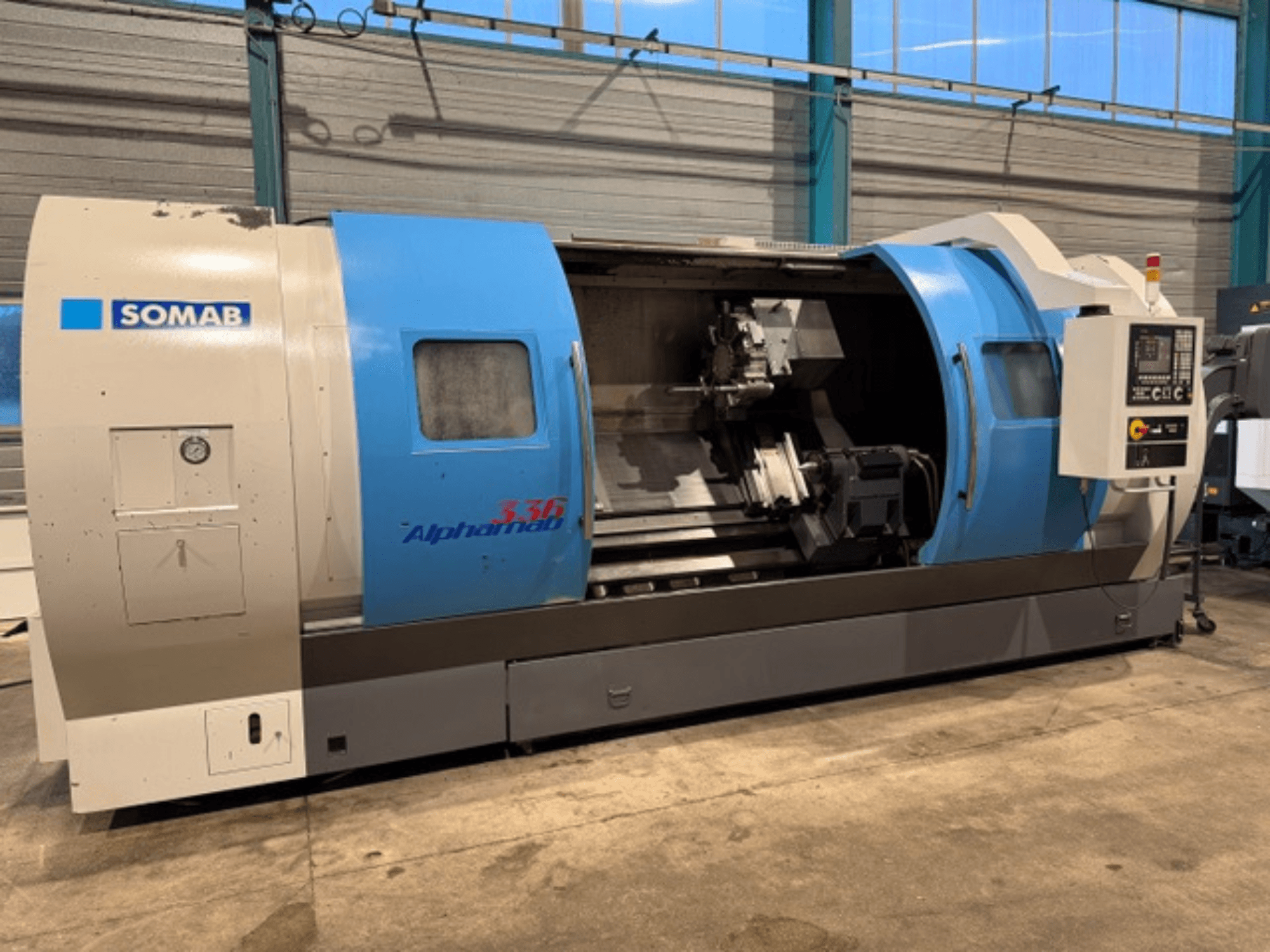 CNC tokarski stroj SOMAB Alpha 336, prednji pogled, s plavim i sivim kućištem i bočnom kontrolnom pločom za upravljanje.