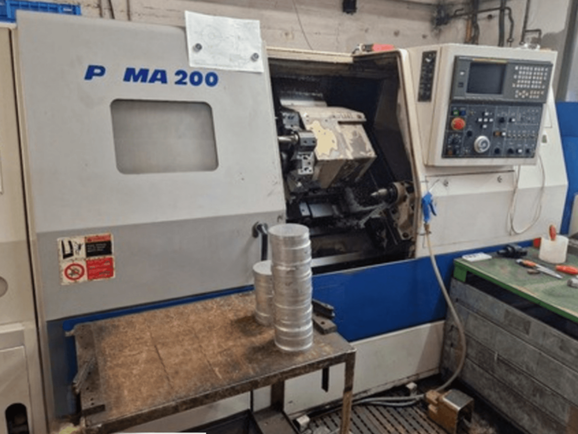 Horizontalni tokarski stroj DAEWOO EcoTurn 200, prednji pogled, s aluminijskim obratcima na stolu, vidljiva upravljačka ploča.