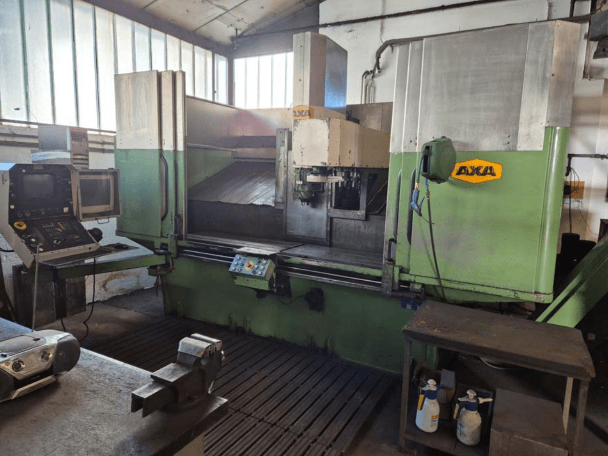 Vertikalni obradni centar AXA VSC-2M, prednji pogled, sadrži upravljačku ploču i radni prostor s alatima za rezanje i sredstvima za čišćenje.