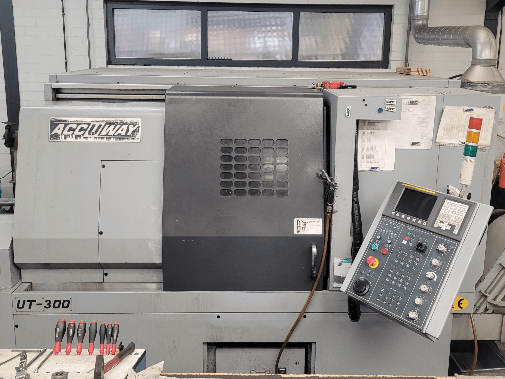 CNC stroj Accuway UT-300 u prednjem pogledu, s upravljačkom pločom i raznim operativnim tipkama, u radioničkom okruženju.