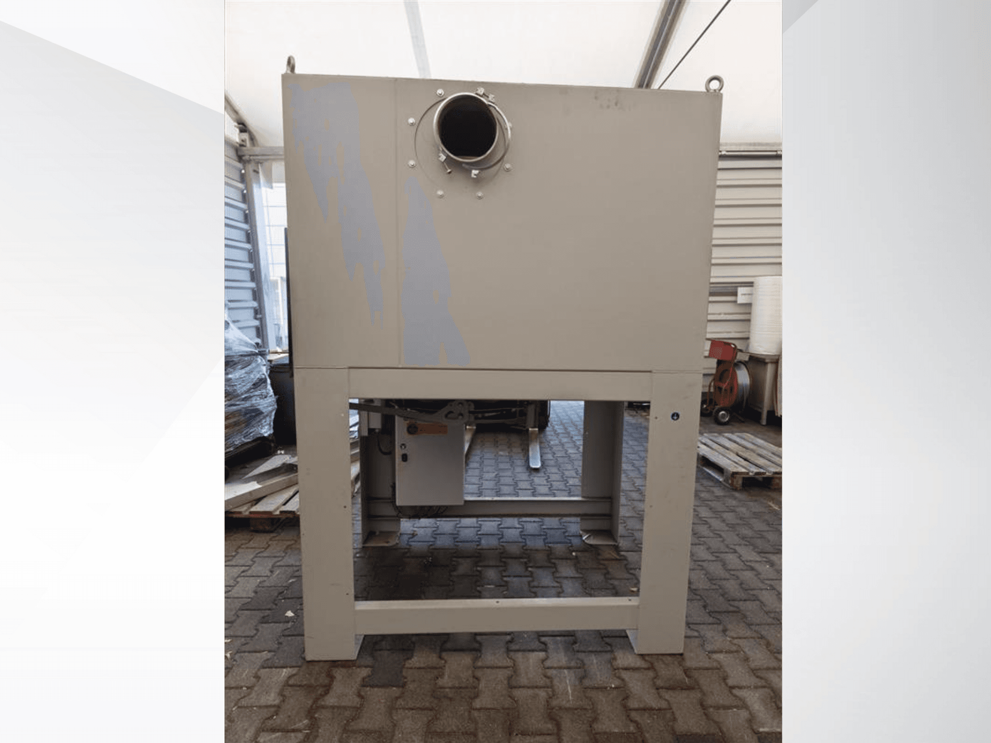 Sivi industrijski sakupljač prašine gledan sprijeda, s velikim okruglim otvorom i postavljen na čvrstu podlogu.