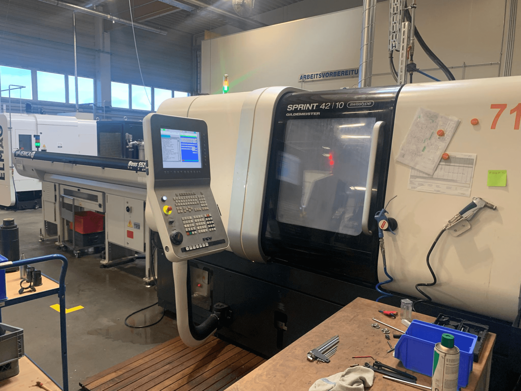 DMG MORI Sprint 42/10 linearni tokarski stroj švicarskog tipa, pogled sprijeda, s upravljačkom pločom i pretrpanim radnim prostorom.
