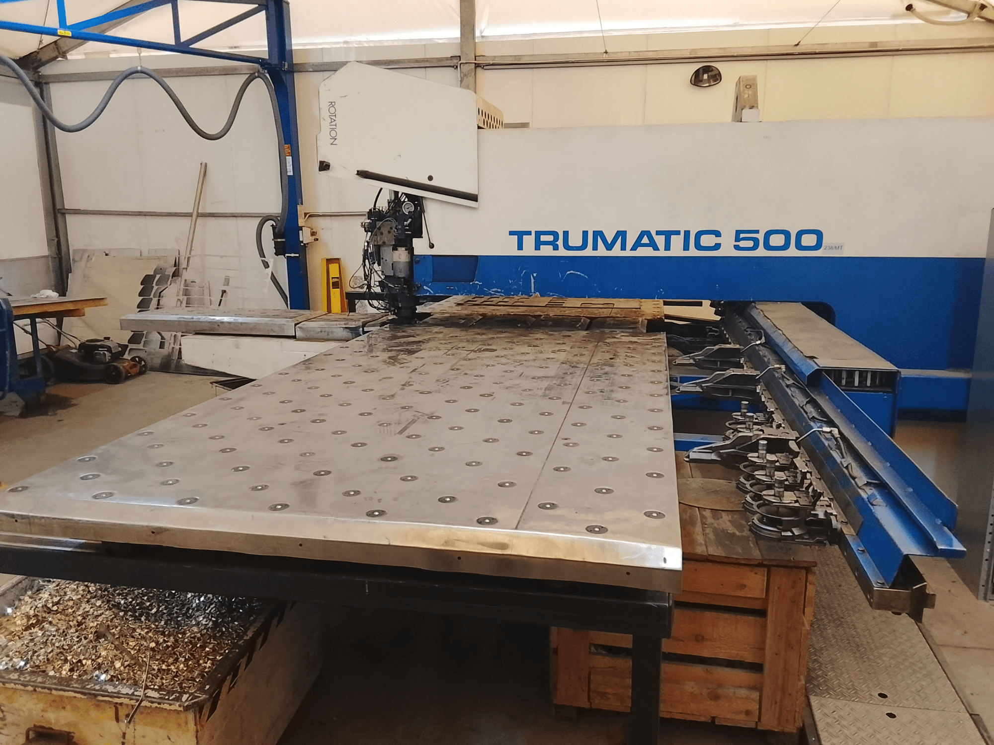 Trumatic 500 CNC stroj, pogled odozgo, s velikim stolom za rezanje metala s montiranim alatima i strugotinama ispod.