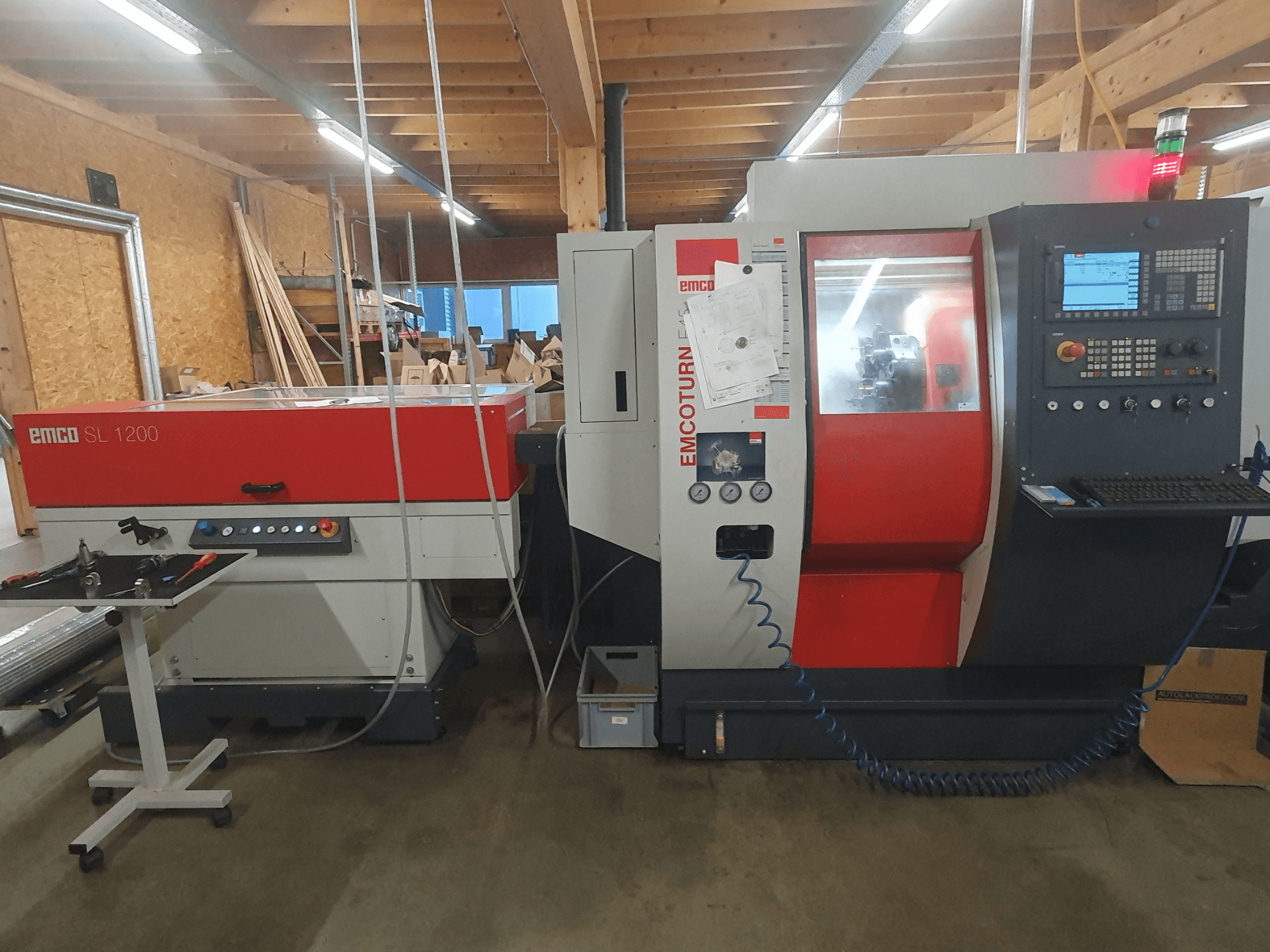 CNC tokarski stroj EMCO SL 1200 i EMCOturn; prednji pogled s prikazom kontrola, zaslona i indikatora rada u radioničkom okruženju.