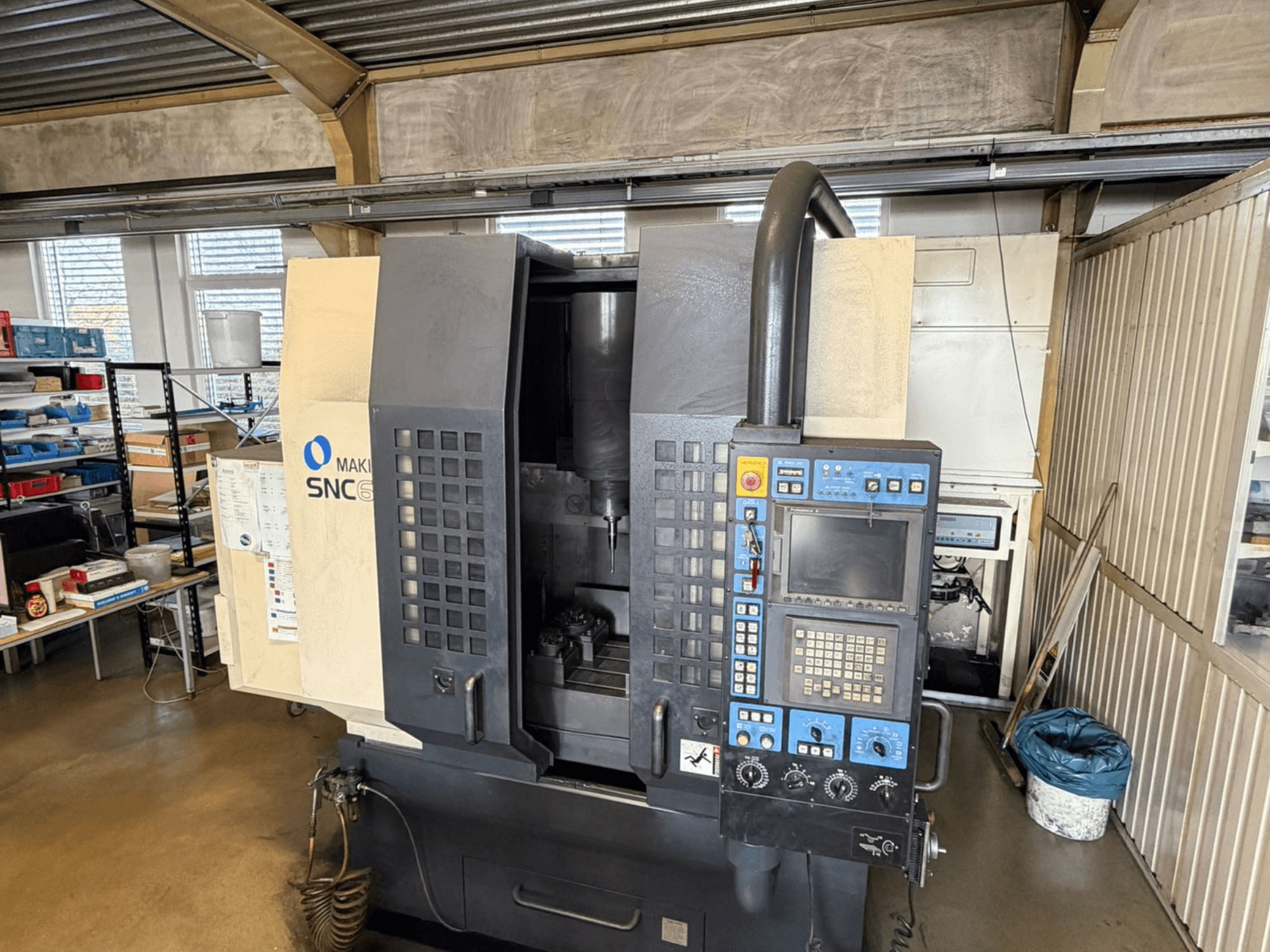 Vertikalni obradni centar Makino SNC 64-A15 u prednjem pogledu, s prikazom upravljačke ploče, područja obrade i industrijskog radnog prostora.