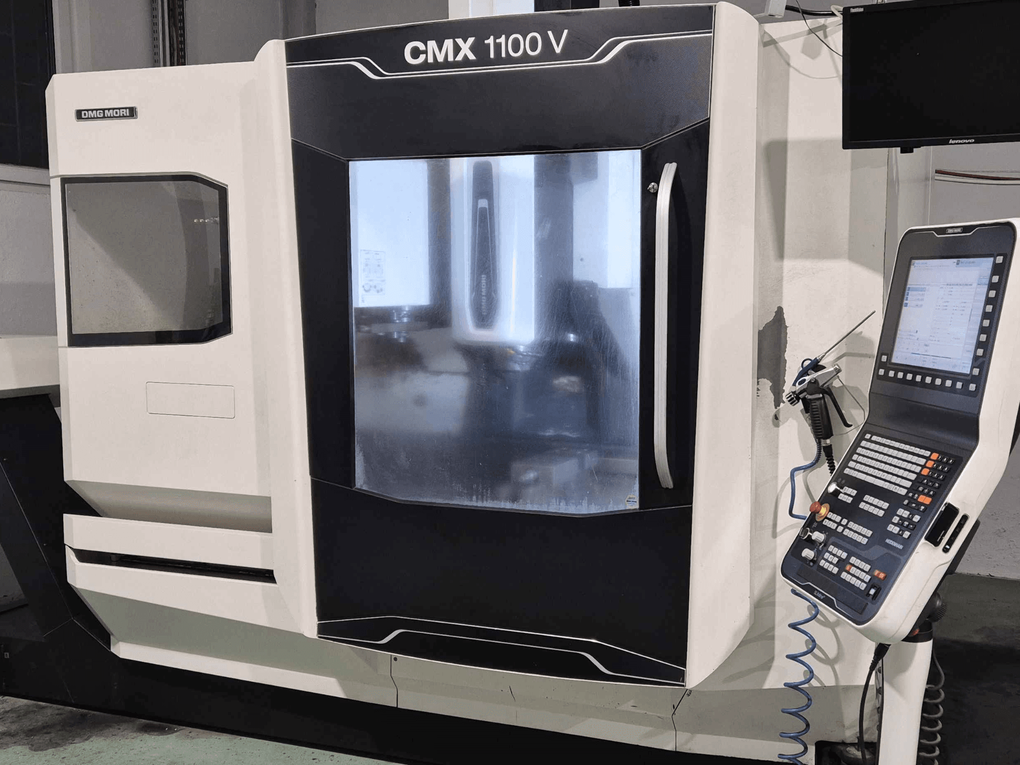 DMG Mori CMX 1100 V, prednji pogled na CNC stroj s vidljivom upravljačkom pločom, digitalnim zaslonom i postavkama rashladnog sredstva.