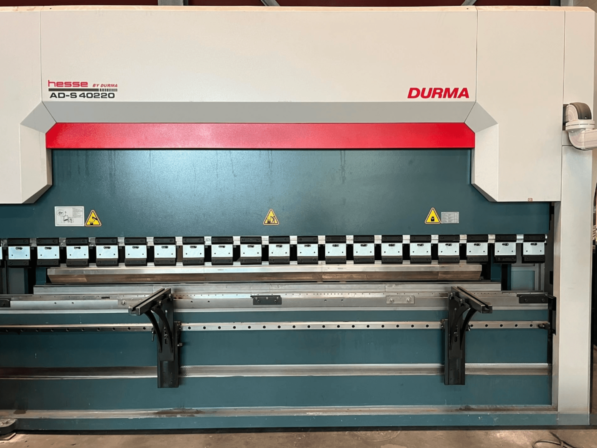 Durma AD-S 40220 preša za savijanje gledana sprijeda, s više alata za savijanje i sigurnosnim naljepnicama.