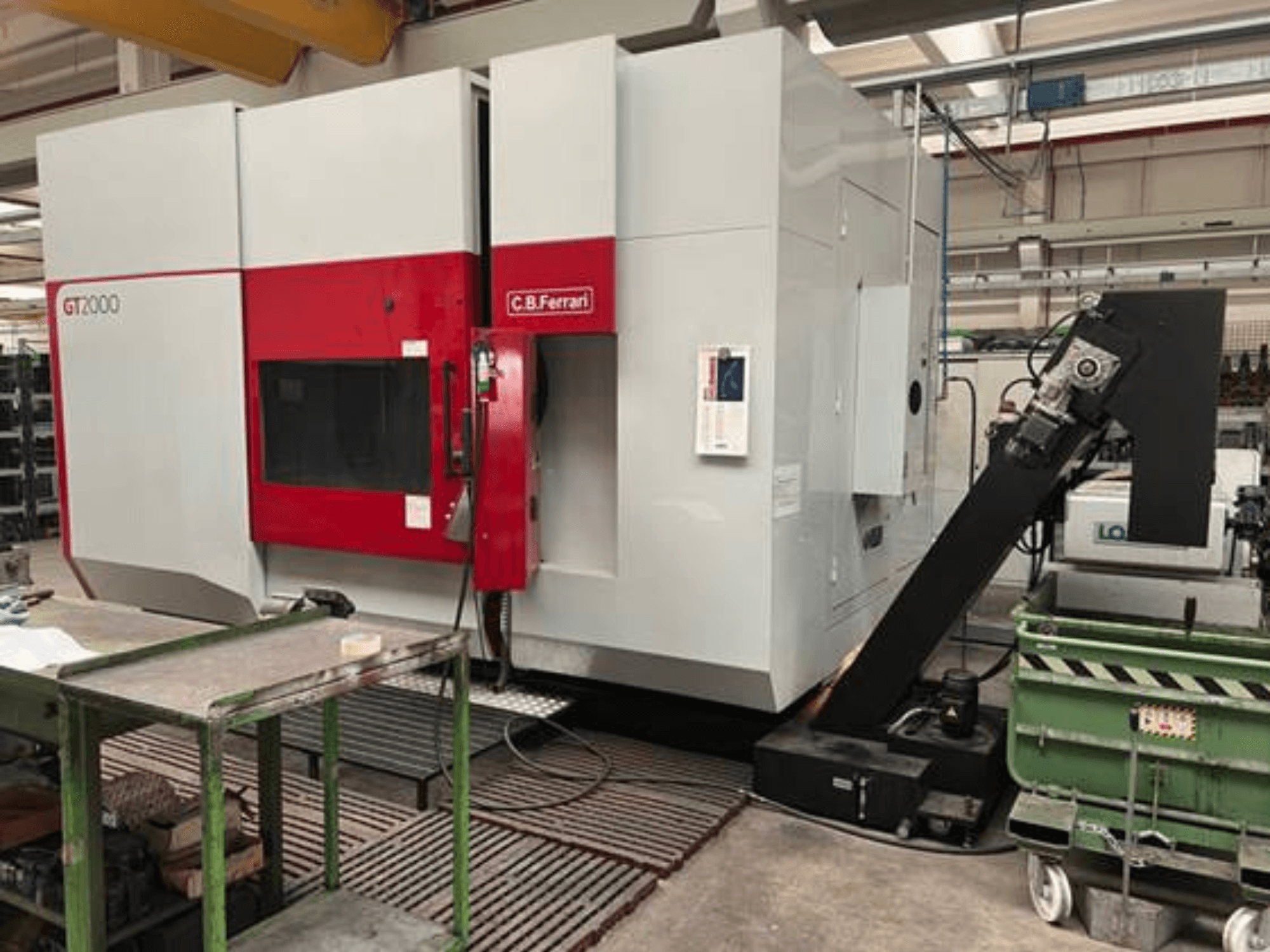 Glodalica CB Ferrari GT2000 u prednjem pogledu, s robotskom rukom i industrijskim radnim prostorom sa zelenim kolicima.