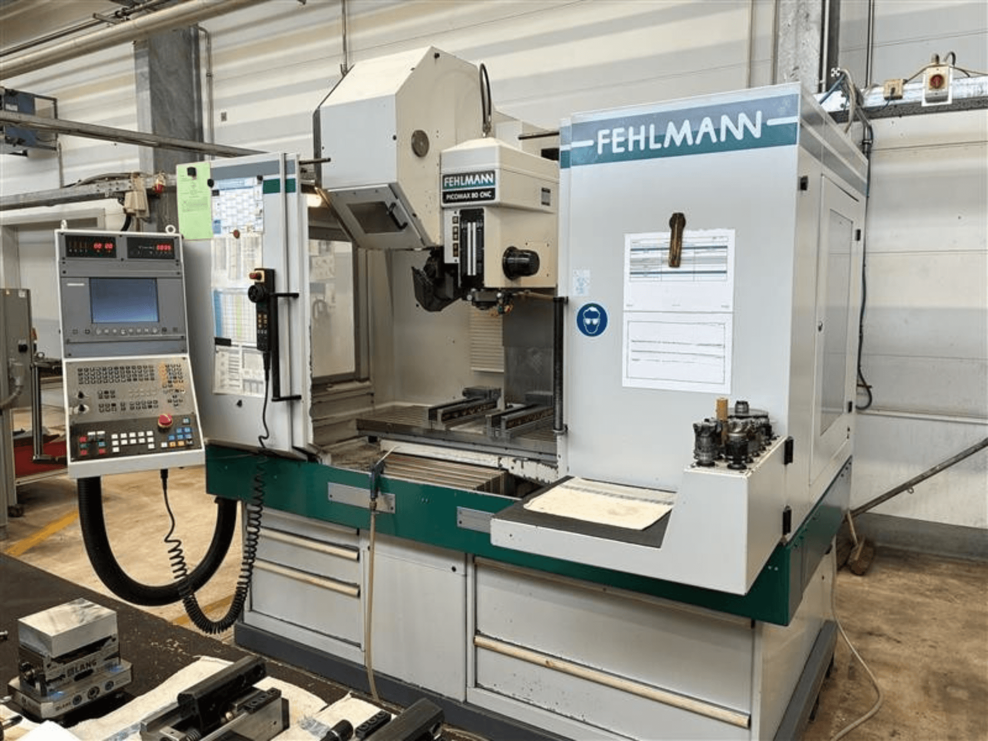 Vertikalni obradni centar FEHLMANN PICOMAX 80 CNC-W 2/3 prikazan s prednje strane, s upravljačkom pločom i radnim prostorom za obradu.