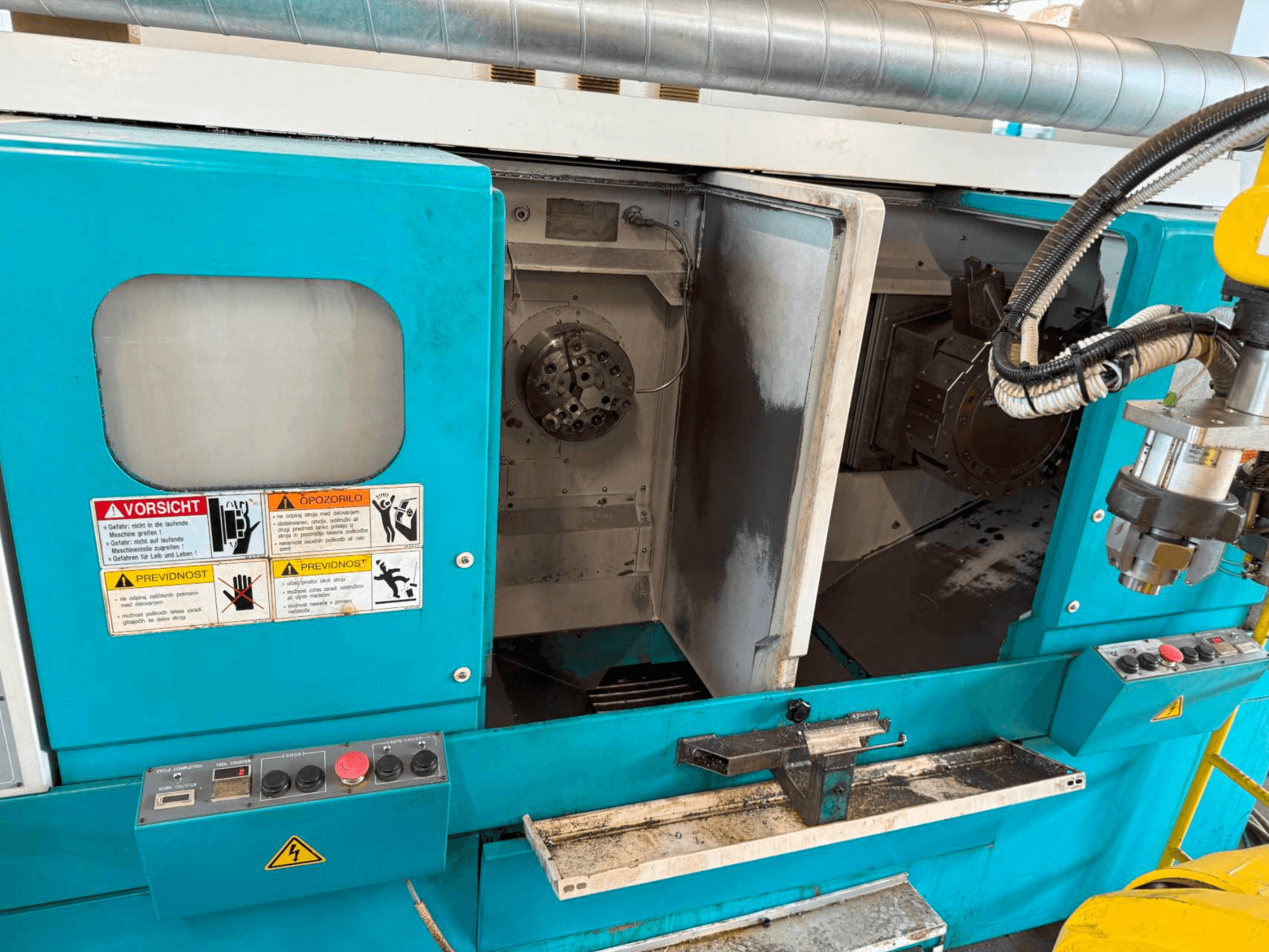 DOOSAN H310T horizontalni tokarski stroj, prednji pogled s upravljačkom pločom i područjem vretena s upozorenjima o sigurnosti.