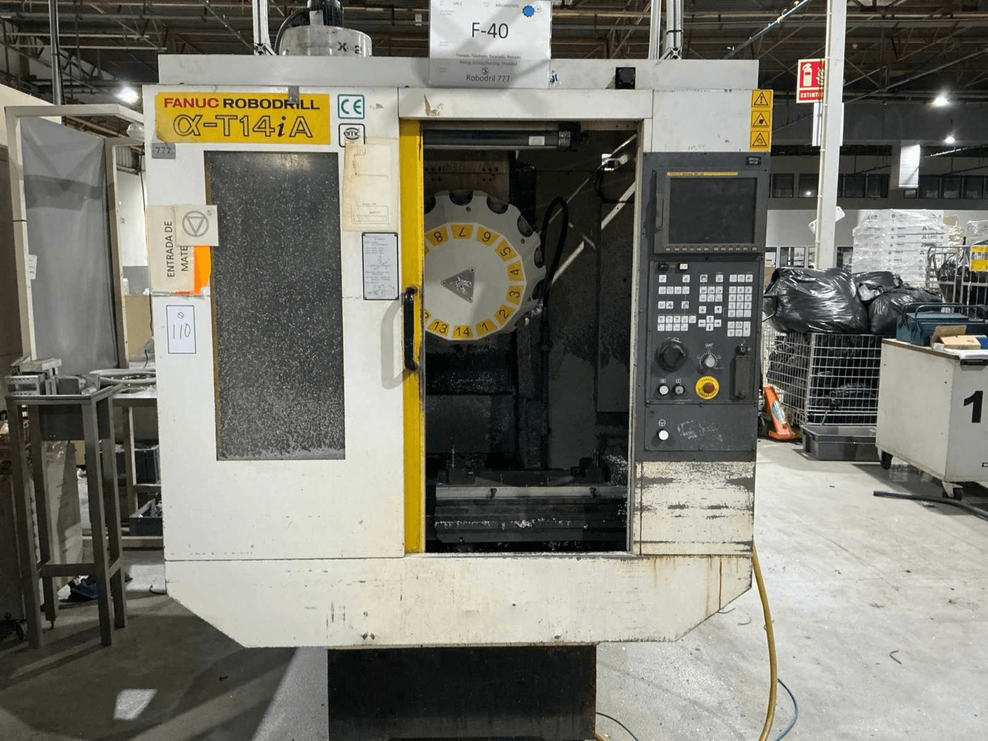 Vertikalni obradni centar FANUC ROBODRILL α-T14iB, prednji pogled koji prikazuje upravljačku ploču i vrtuljak alata.