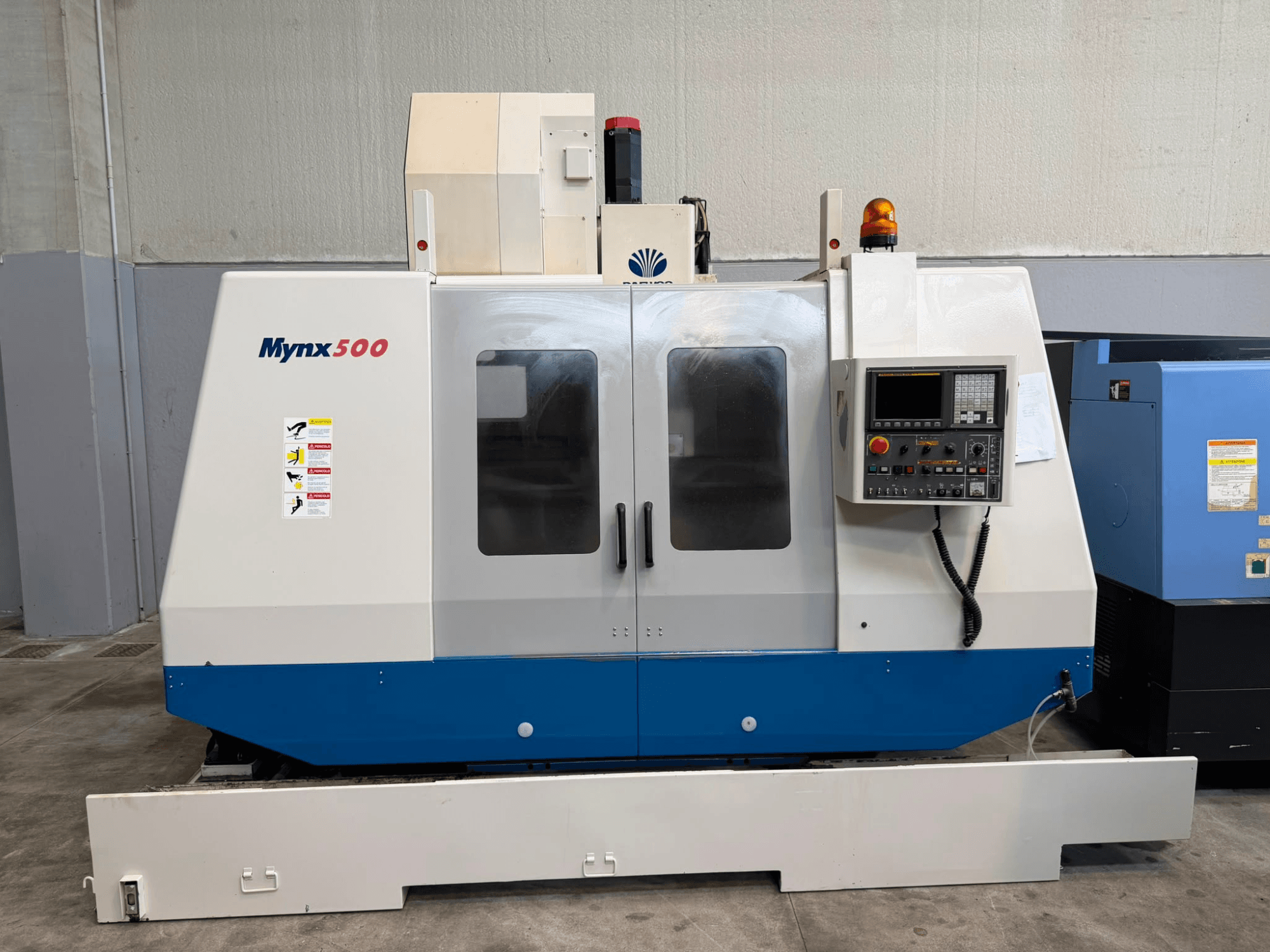 Vertikalni obradni centar DAEWOO MYNX 500 u prednjem pogledu s upravljačkom pločom, sigurnosnim svjetlima i prozirnim pristupnim vratima.