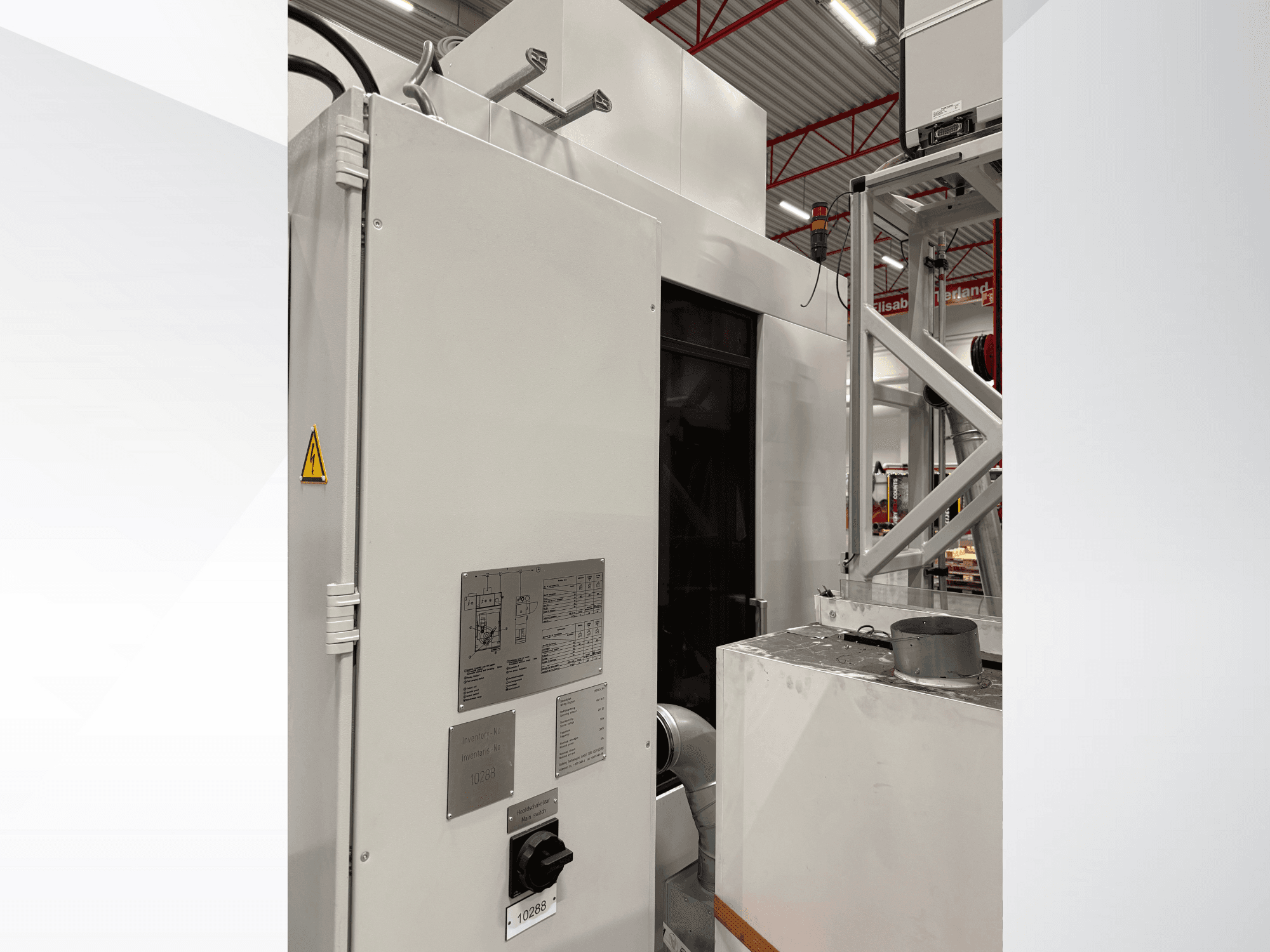 Bočni pogled na bijeli industrijski stroj s upravljačkom pločom i naljepnicom upozorenja, dio automatiziranog sustava.