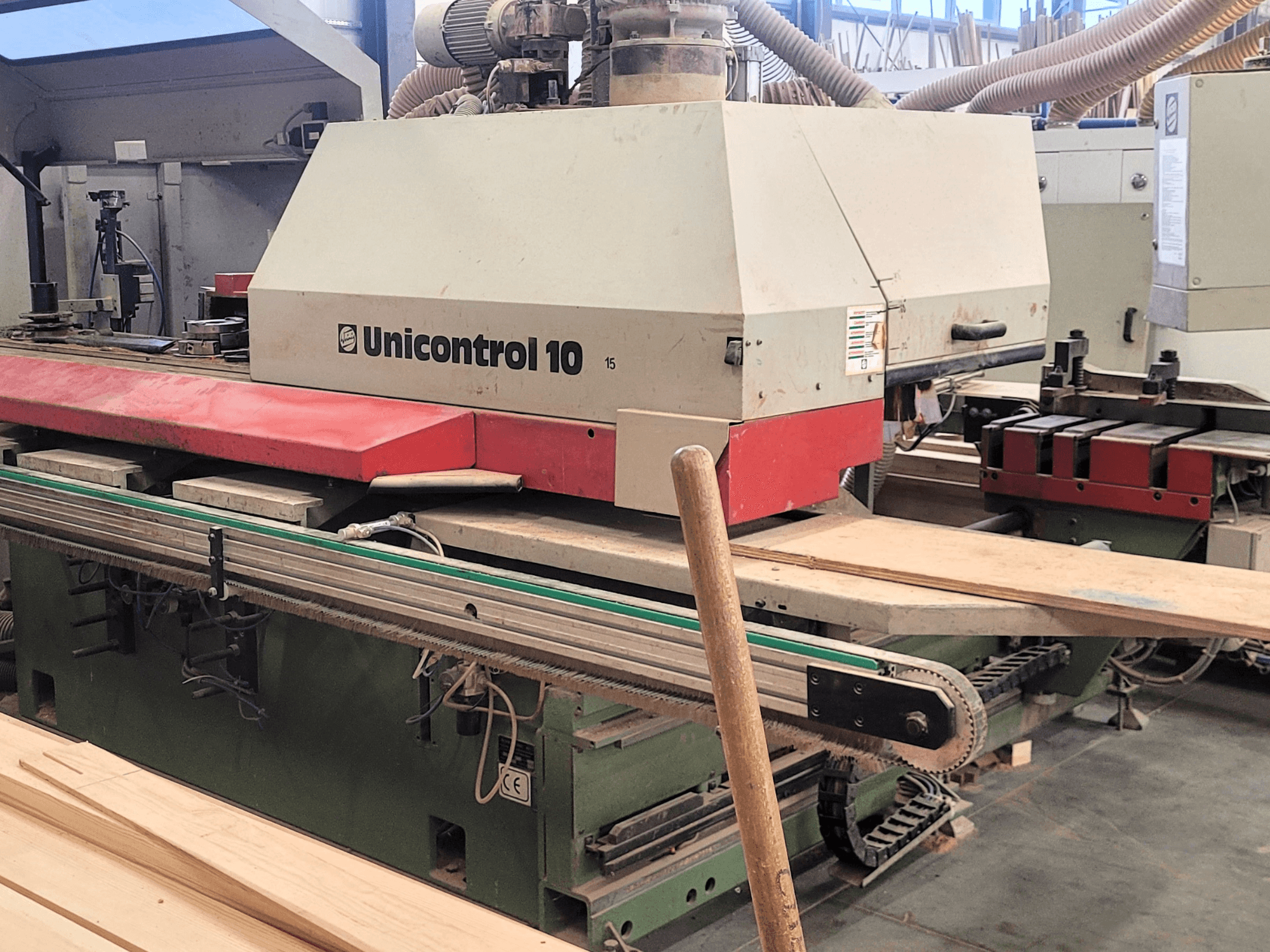 CNC obradni centar Unicontrol 10 tvrtke WEINIG/DIMTER, prednji pogled s drvenim pločama i opremom u radioničkom okruženju.