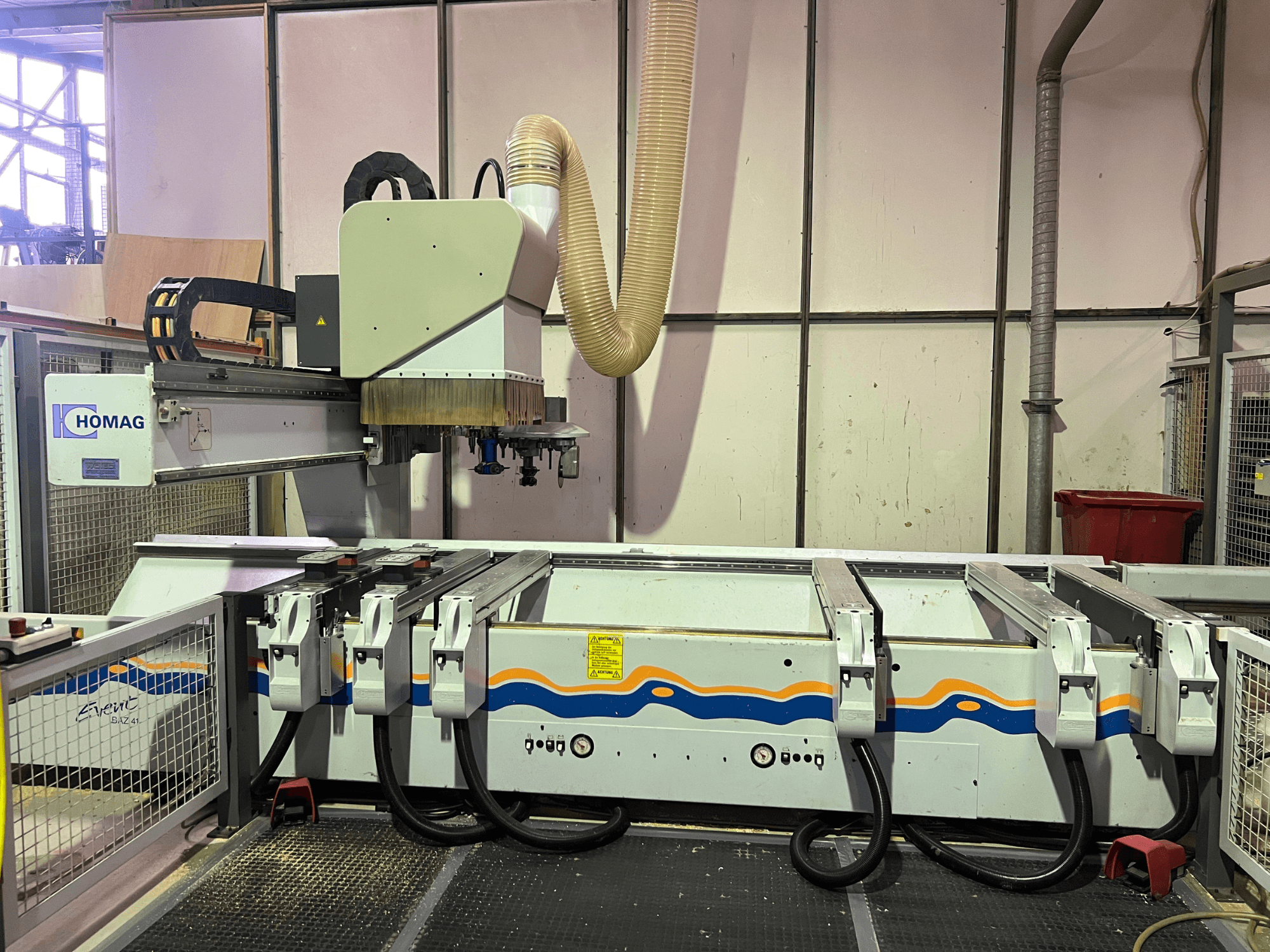 HOMAG BIZ 4 CNC stroj u radionici; prednji pogled koji prikazuje sustav za usisavanje prašine i upravljačku ploču s kabelima.