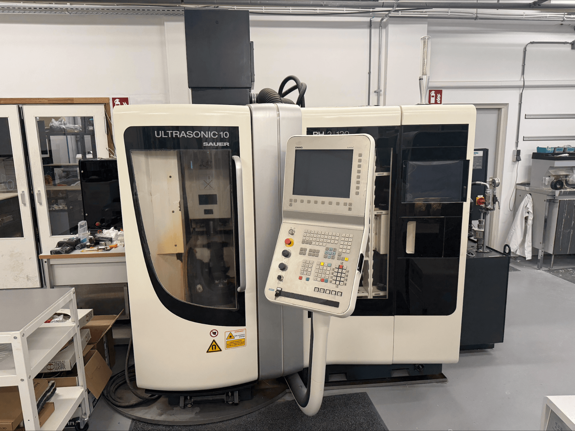 DMG Sauer Ultrasonic 10 + PH 2 | 120 vertikalni obradni centar, prednji pogled, s upravljačkom pločom i velikim prozorom za pregled.