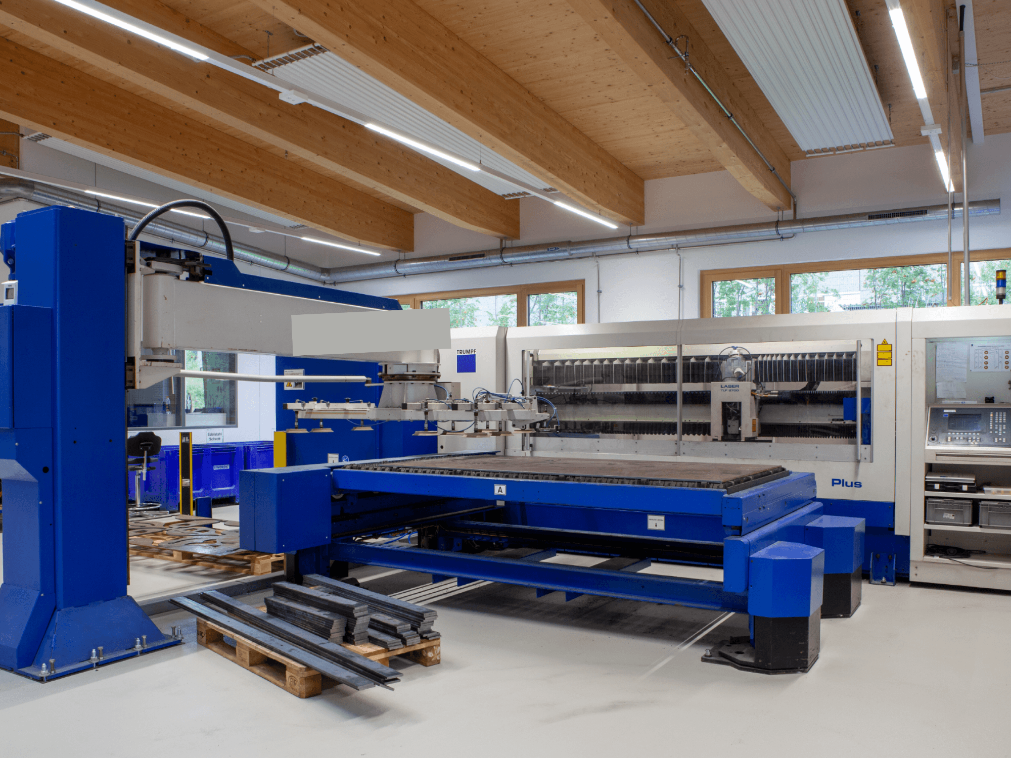 Stroj za rezanje CO2 laserom TRUMPF TRUMATIC L 2530 Plus u radionici, s velikom površinom za rezanje i industrijskim dizajnom.