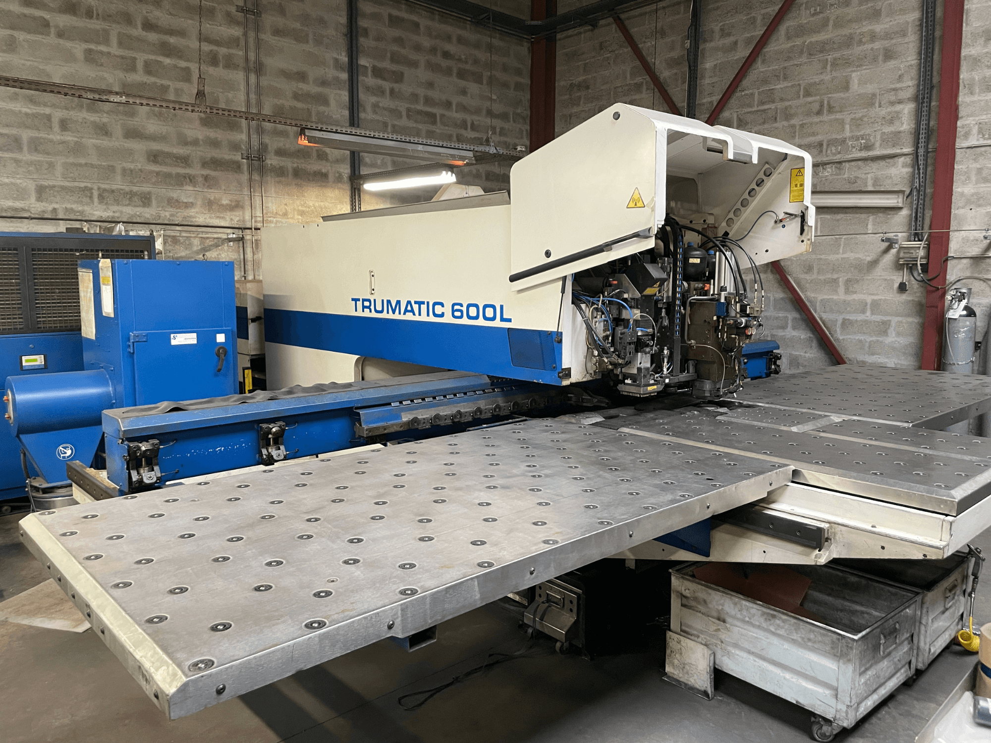 Stroj za CO2 lasersko rezanje TRUMPF TRUMATIC TC 600L, prednji pogled s vidljivim stolom za rezanje metala i upravljačkom pločom.