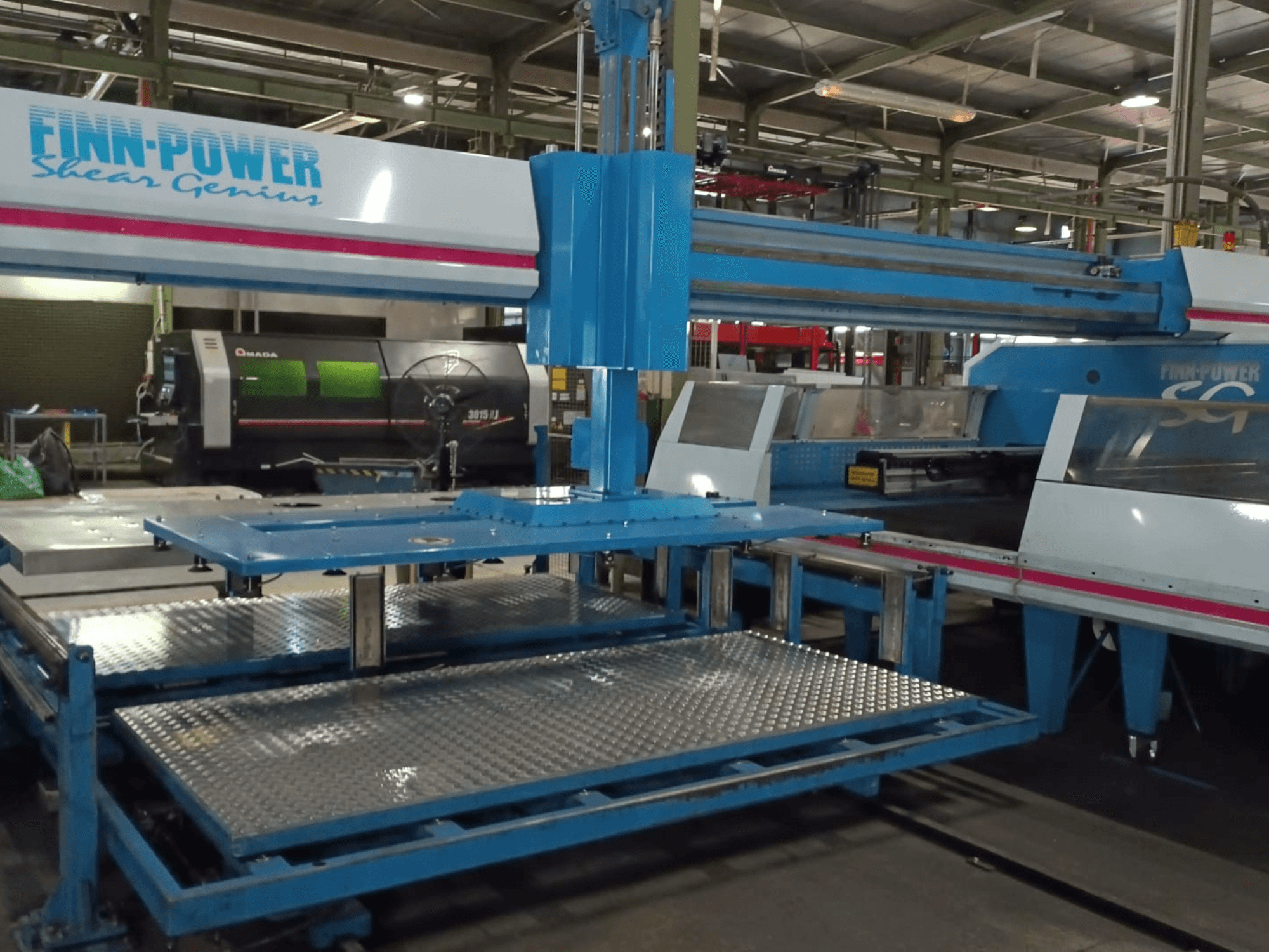 CNC probijačka mašina Finn-Power SG6 Shear Genius u prednjem pogledu, s metalnim stolovima i strukturnim značajkama.
