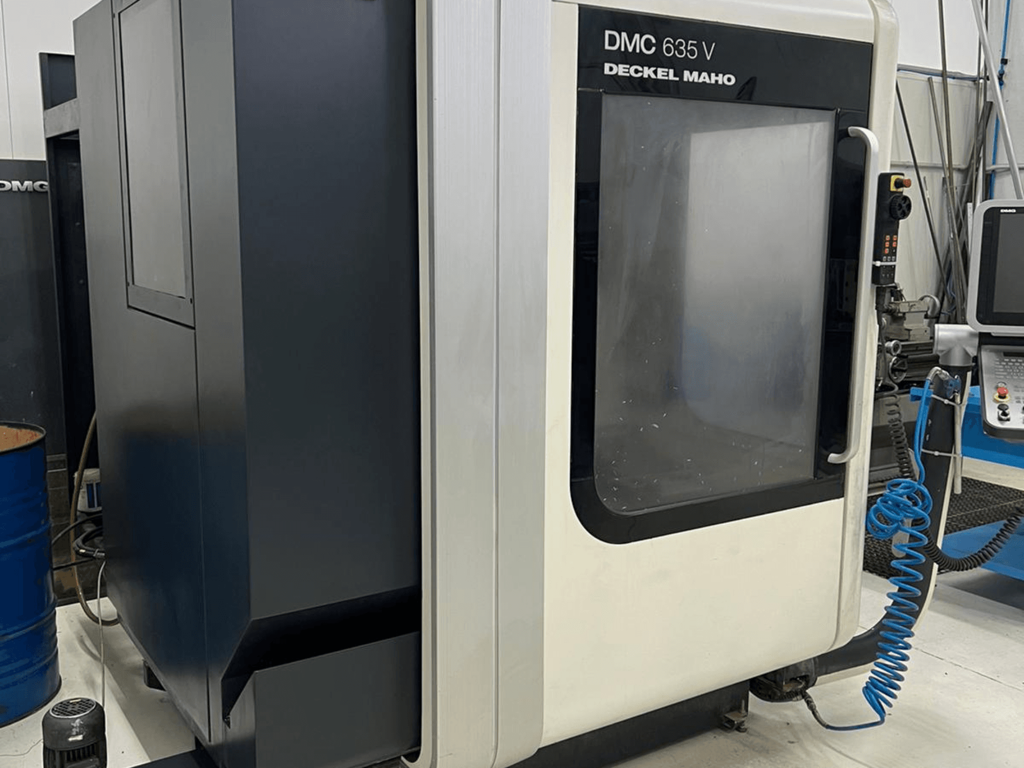 Glodalica DMC 635 V tvrtke Deckel Maho, bočni pogled s upravljačkom pločom i djelomično otvorenim pristupnim vratima.