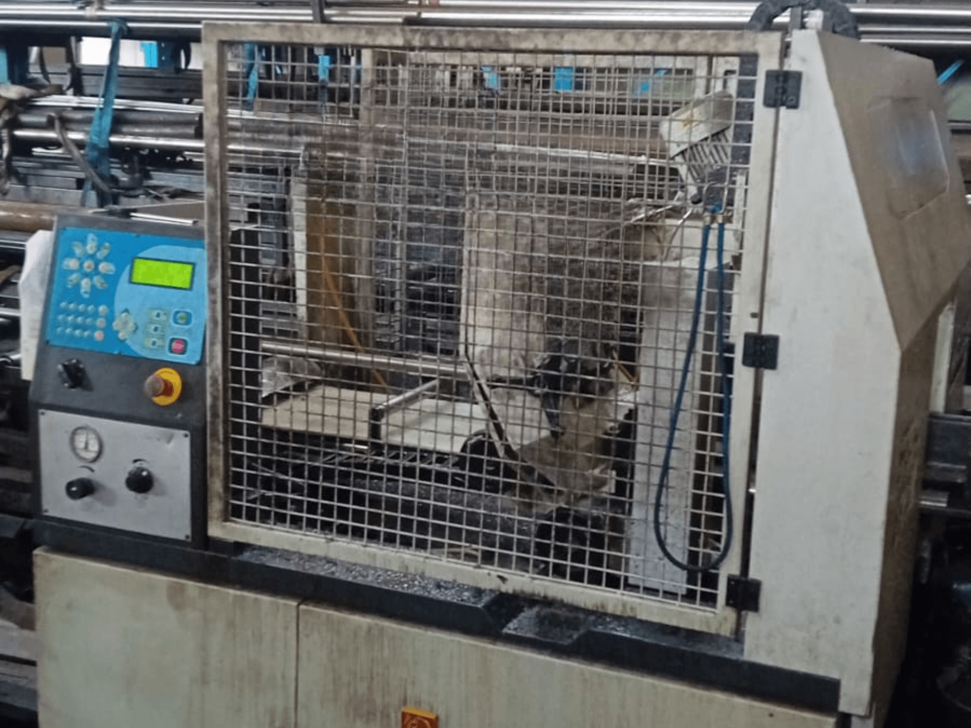 Tračna pila za metal Macc 381 AV, prednji pogled, prikazuje upravljačku ploču, sigurnosni kavez i ostatke metala na podnožju.