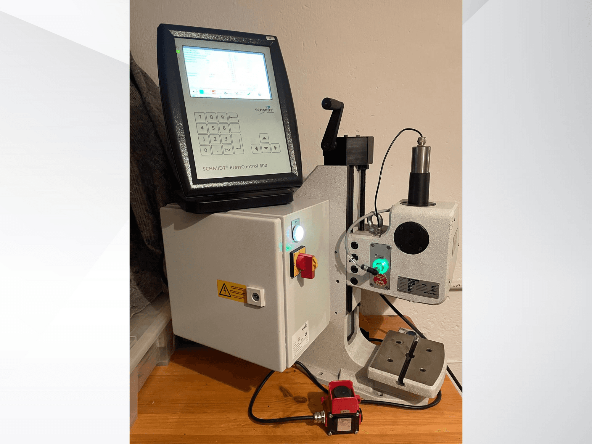 SCHMIDT® PressControl 600, prednji pogled, prikazuje upravljačku ploču, gumb za uključivanje/isključivanje i hidrauličku prešu sa sigurnosnim značajkama.