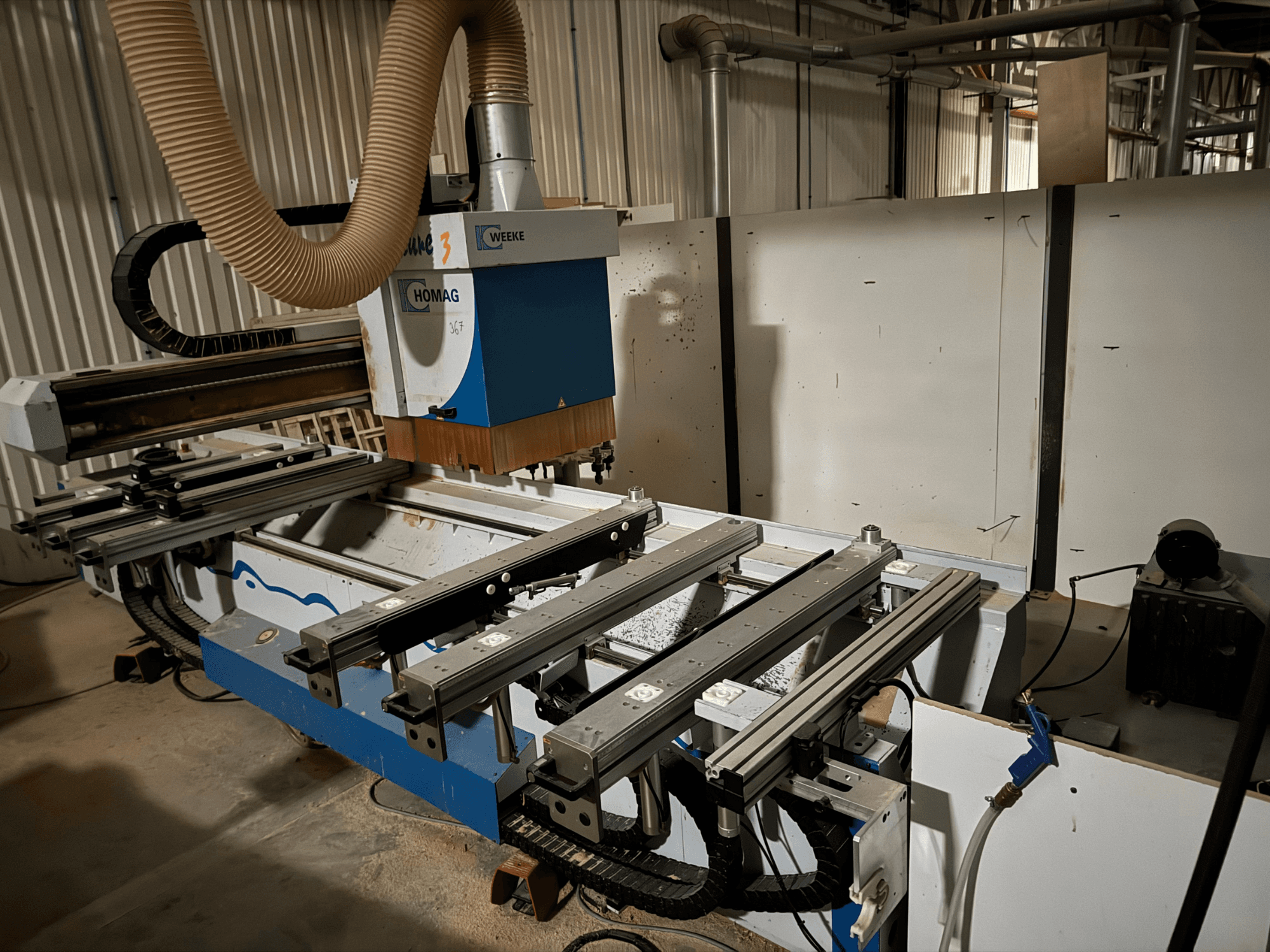 HOMAG CNC stroj s plavo-bijelim dizajnom, bočni pogled, ima klizne vodilice, sustav za usisavanje prašine i montirane alate.