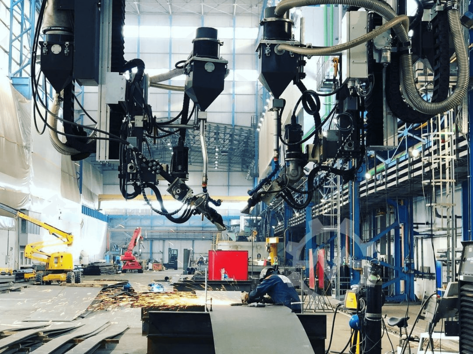 Robotski stroj za rezanje u industrijskom okruženju, s iskrama koje lete, gledano sa strane; ima više nastavaka i crijeva.