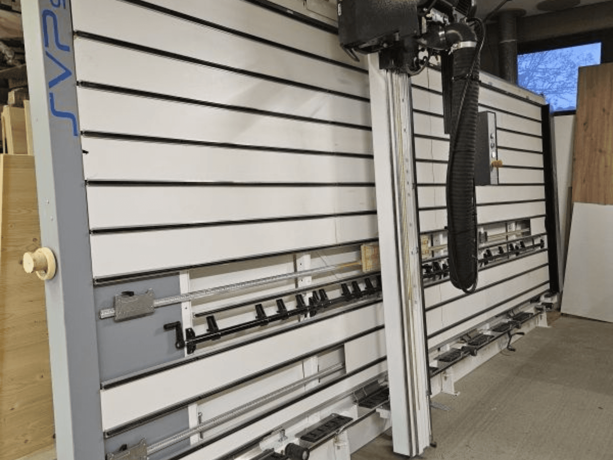 SVP klizna pločasta pila u radionici, pogled sprijeda, s podesivim tračnicama i sustavom za usisavanje prašine iznad glave.