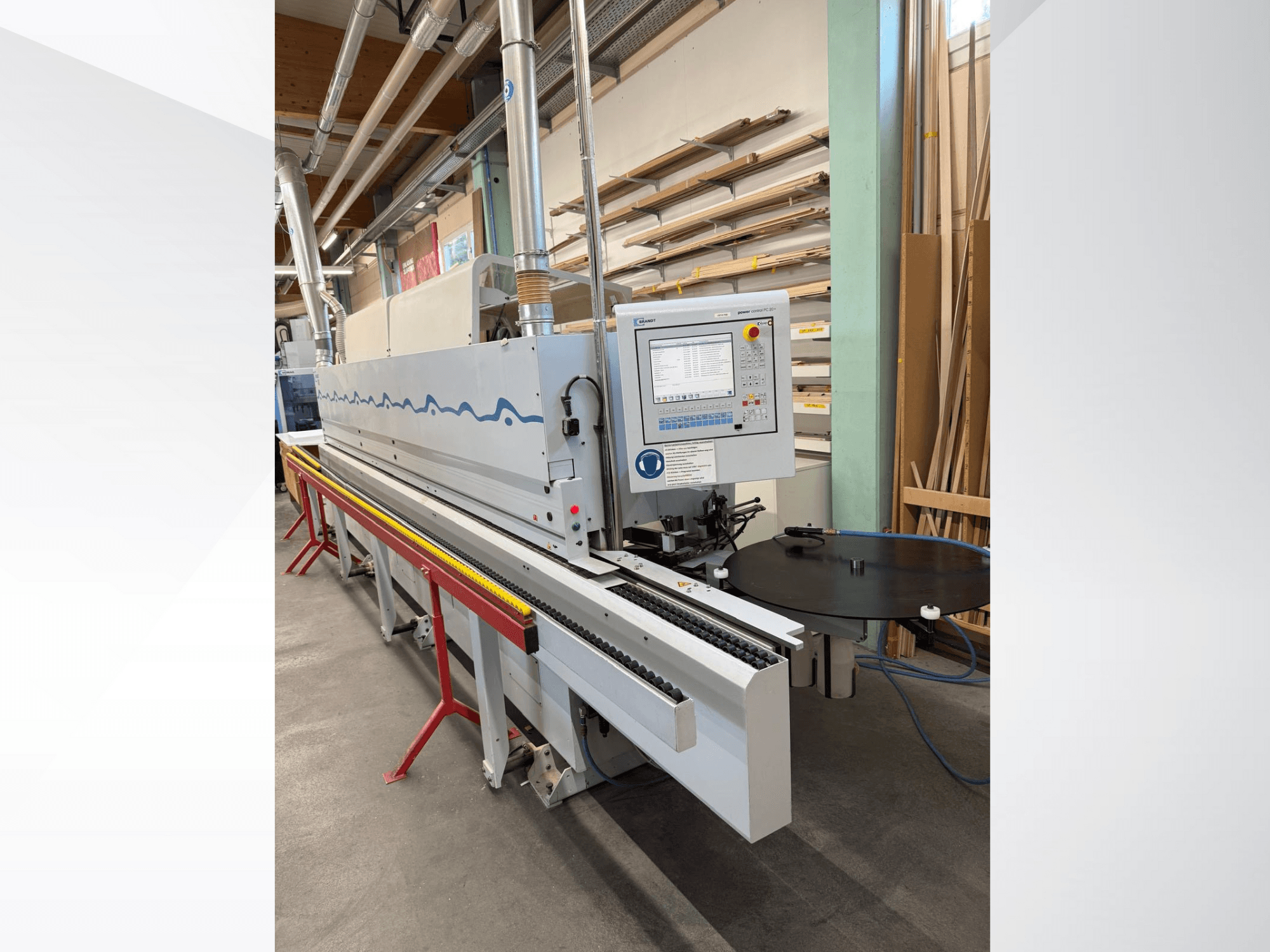 Prednji pogled na automatski stroj za obradu rubova HolzHer s upravljačkom pločom, transportnim sustavom i okruglim potpornim stolom.