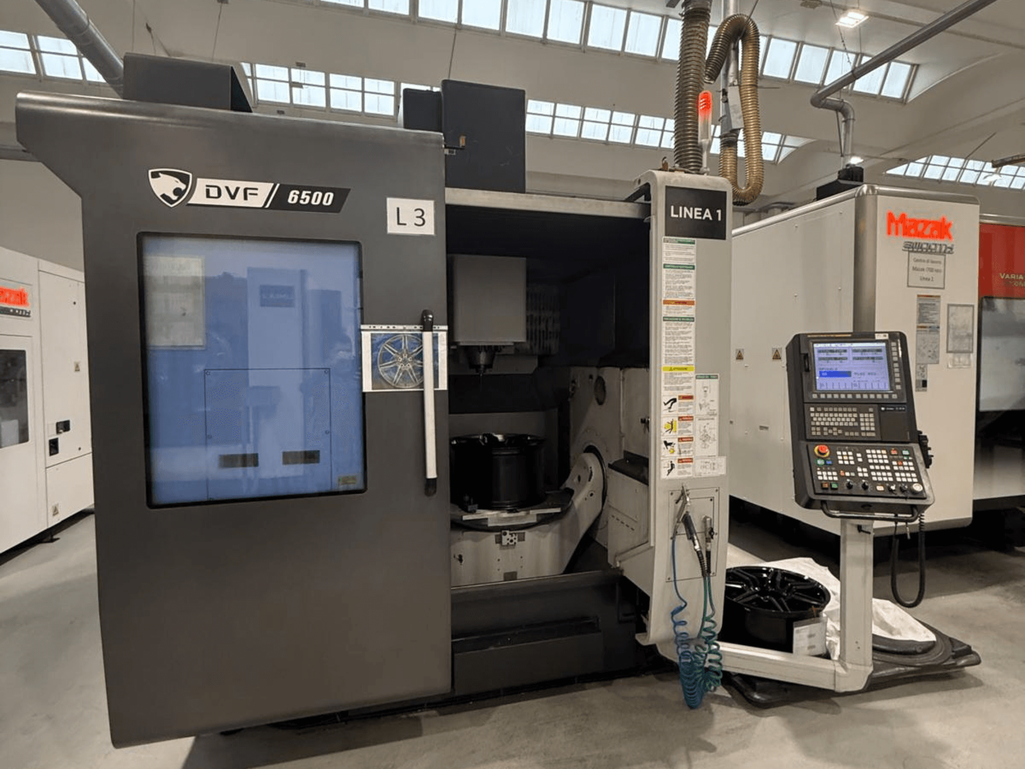 DVF 6500 CNC stroj, prednji pogled, prikazuje upravljačku ploču i unutarnji prostor s prihvatom za dio.