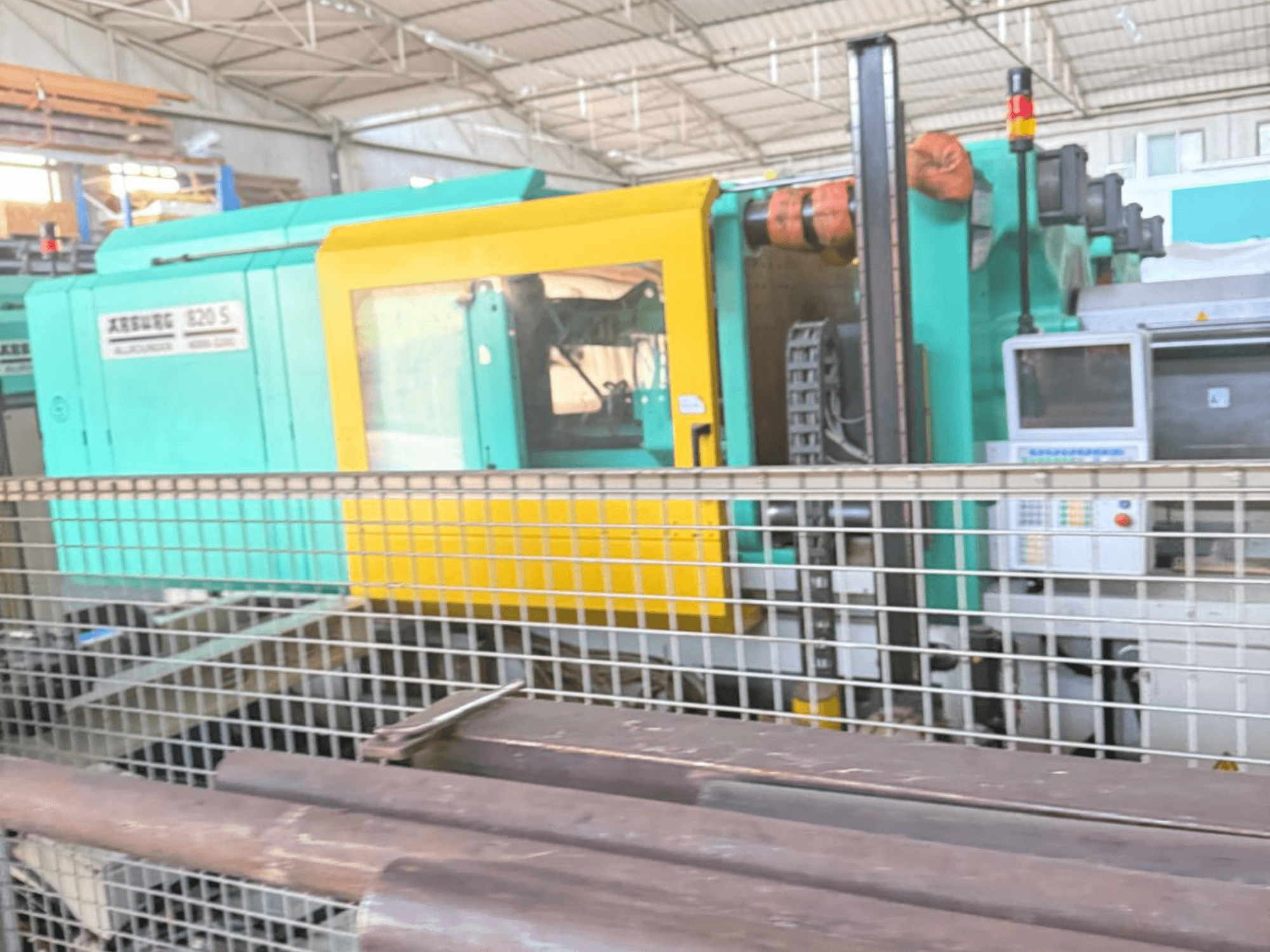 Hidraulički stroj za brizganje plastike Arburg SELECTA 820 S 4000-3200, bočni pogled, s upravljačkom pločom i živopisnim žuto-tirkiznim dizajnom.